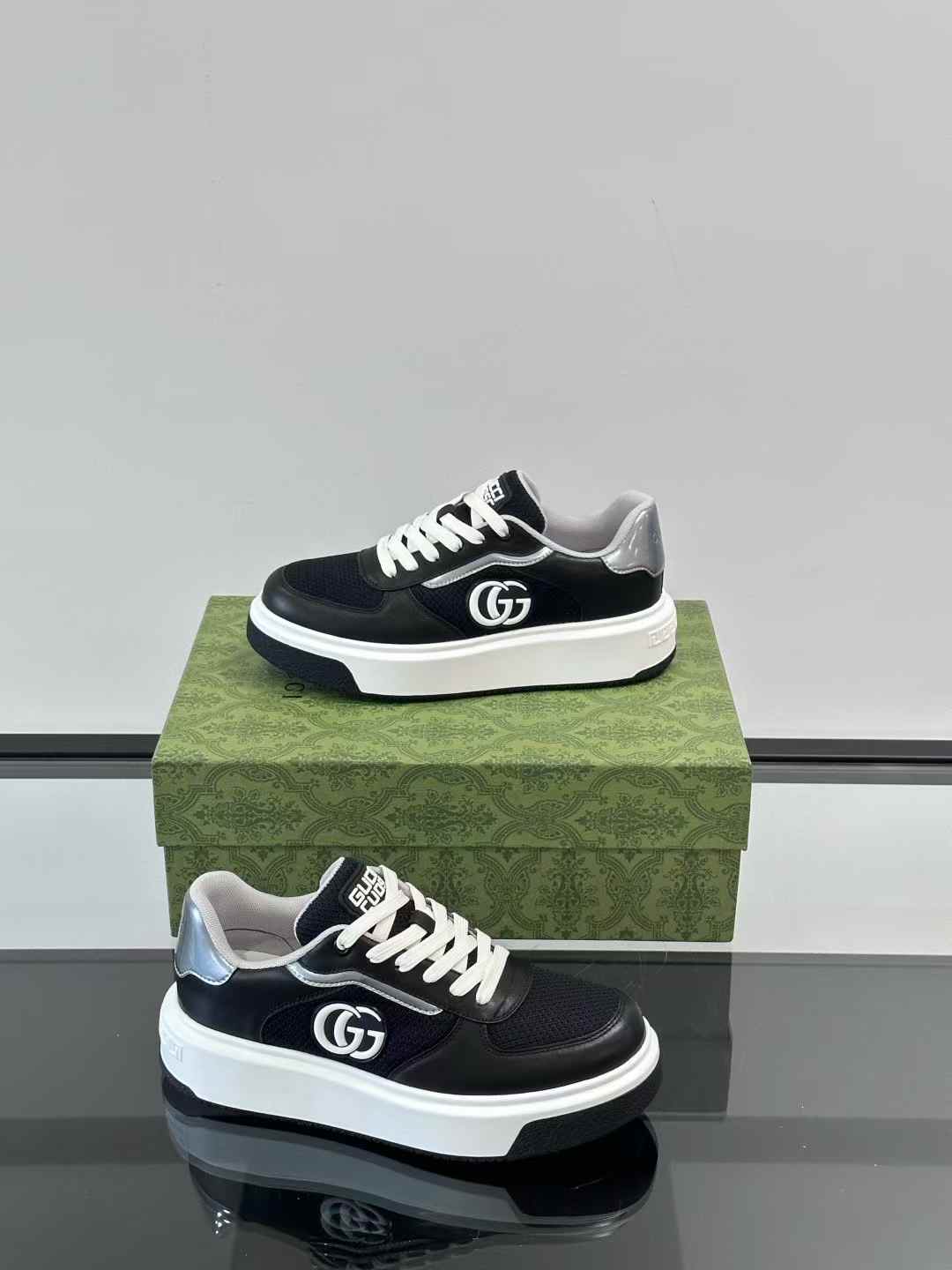 Gucci black and silver sneakers featuring the interlocking 'G' logo on the side