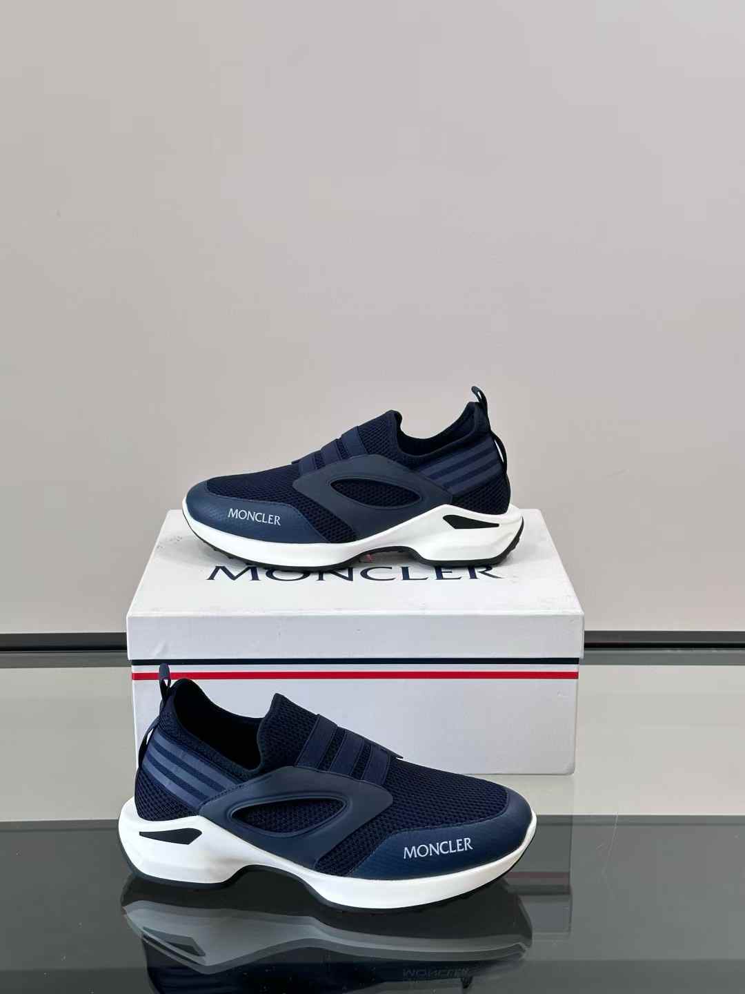 moncler navy blue slip-on sneakers with a white sole and a logo on the front side