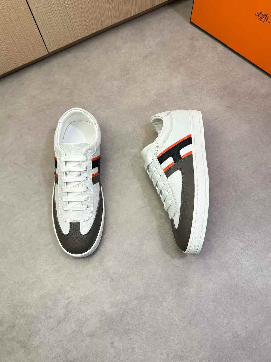 Hermès Boomerang sneakers in white Epsom calfskin with a brown suede toe cap and an orange and black stripe detail
