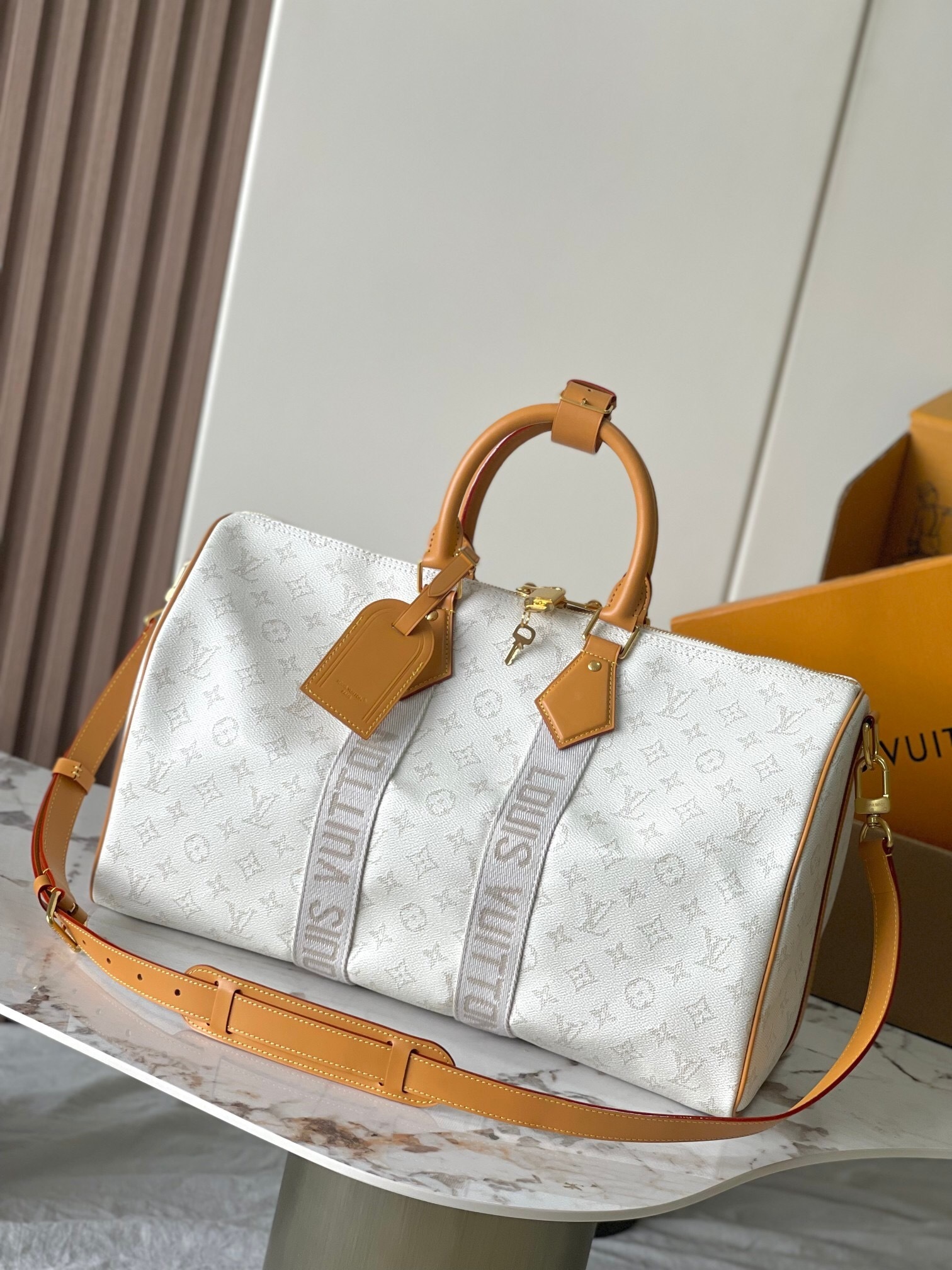 LV Keepall Bandoulière 45 bag in a white and grey monogram canvas with natural cowhide-leather trim