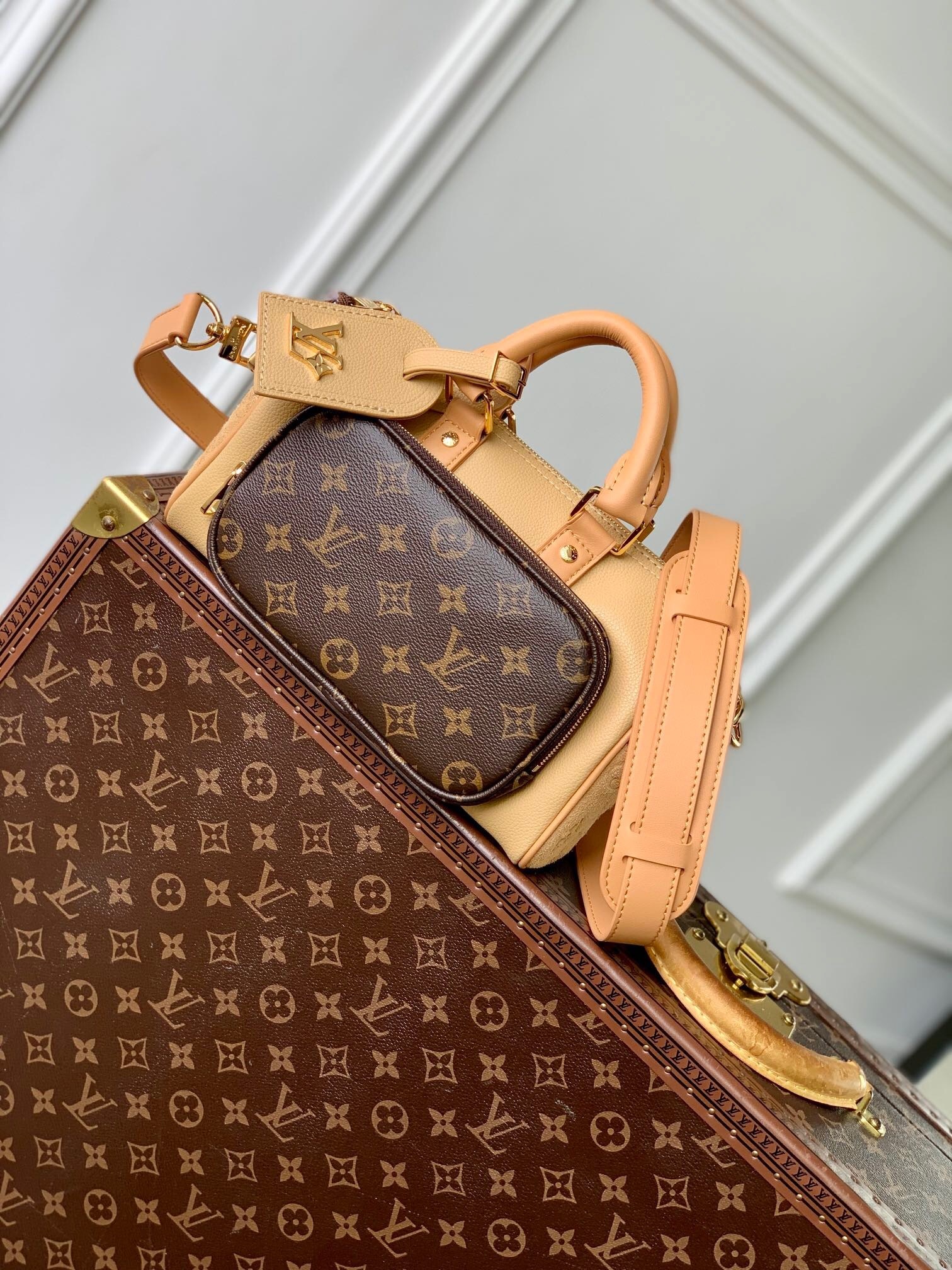 LV Keepall Bandoulière 25 bag in beige grained leather with a Monogram canvas external pocket