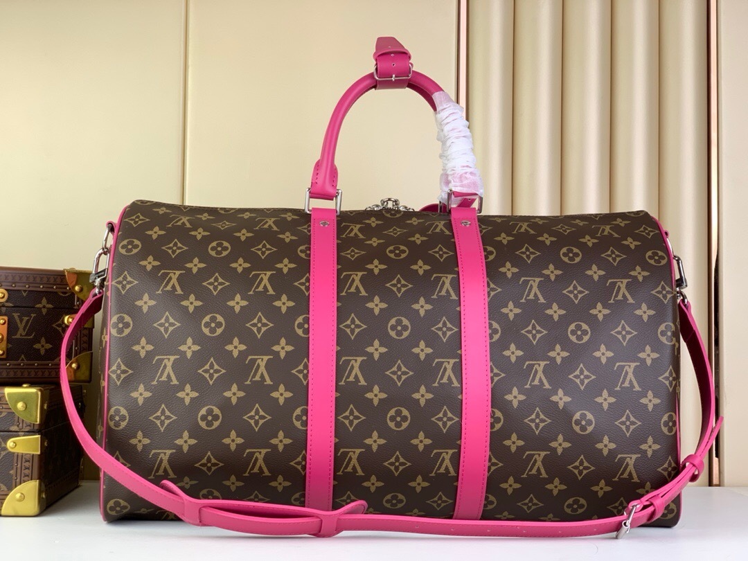 LV Keepall Bandoulière 50 travel bag in monogram canvas with bright pink cowhide-leather trim.