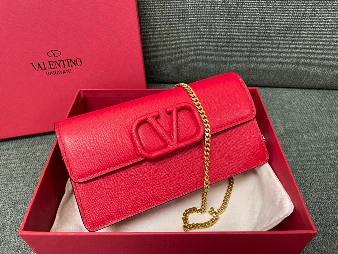 Valentino Garavani VLogo Signature clutch bag in red grained calfskin with a gold-tone chain strap