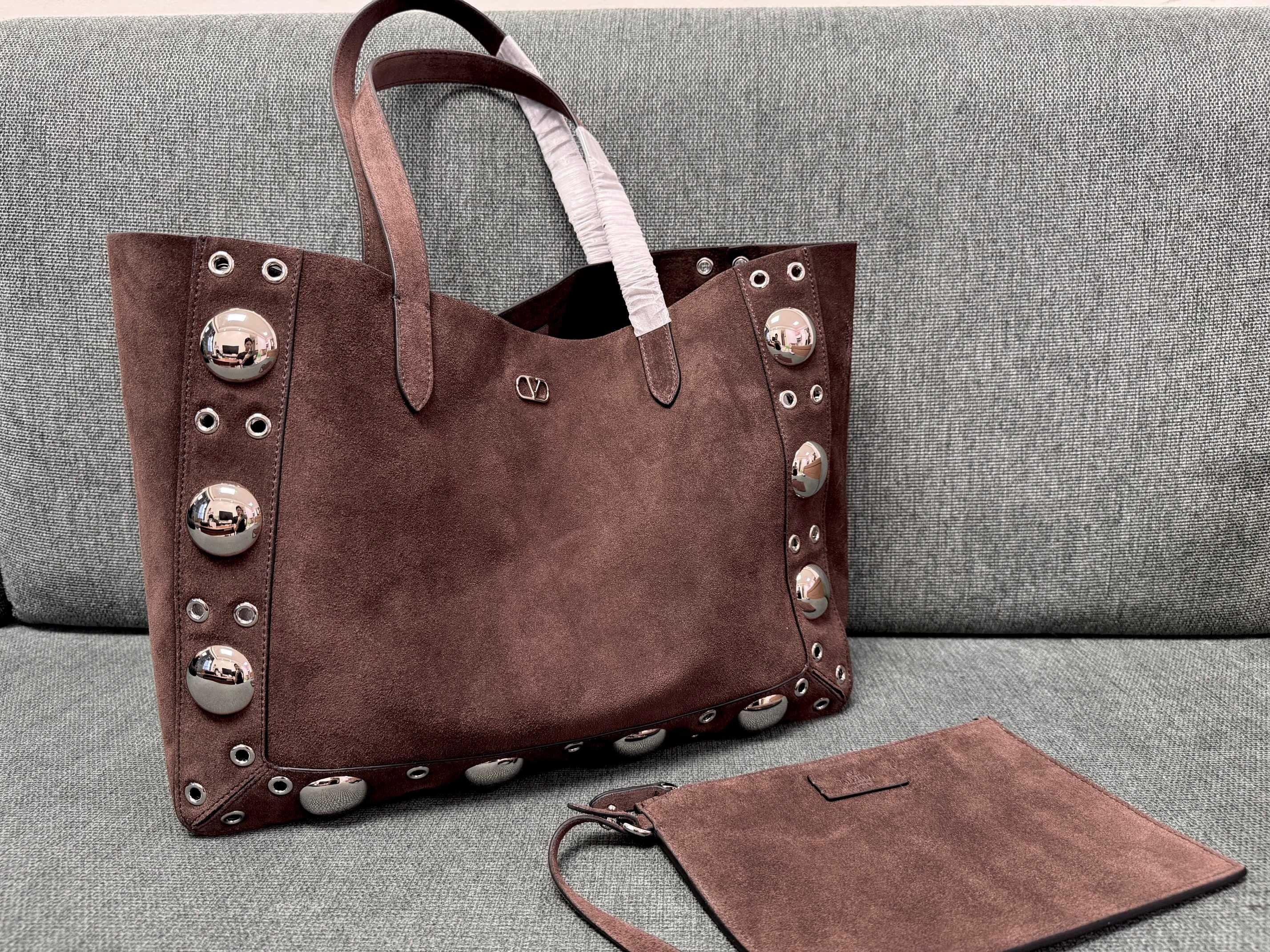 Valentino Garavani Nellcôte large suede shopping bag in a brown color, detailed with ball studs and rivets along the trim