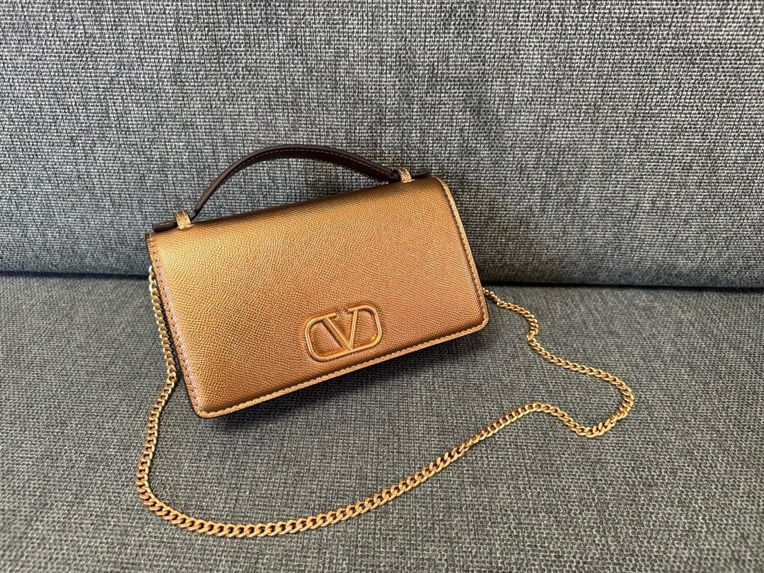 Valentino Garavani V-Logo Signature wallet on chain in a gold-tone metallic leather finish