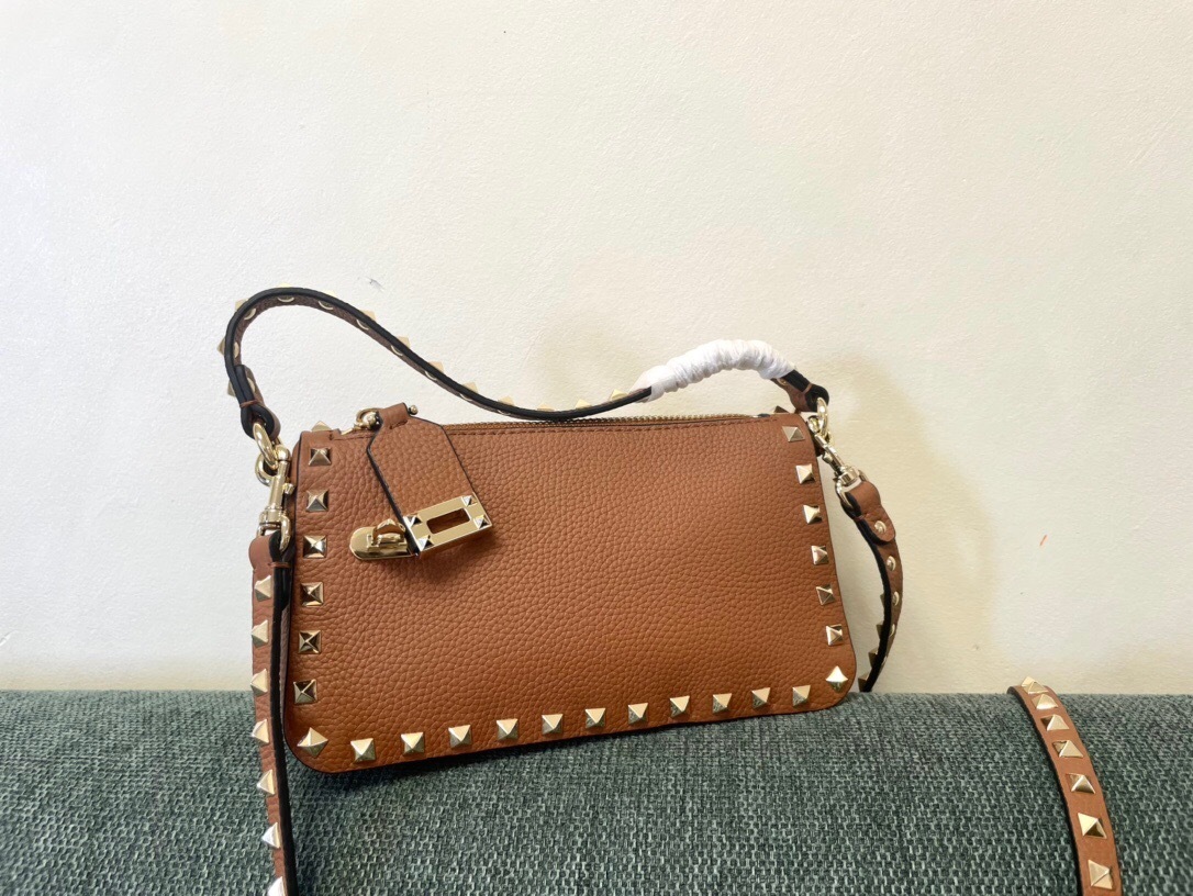 Valentino Garavani small Rockstud crossbody bag in grainy calfskin leather with platinum-finish metal studs.