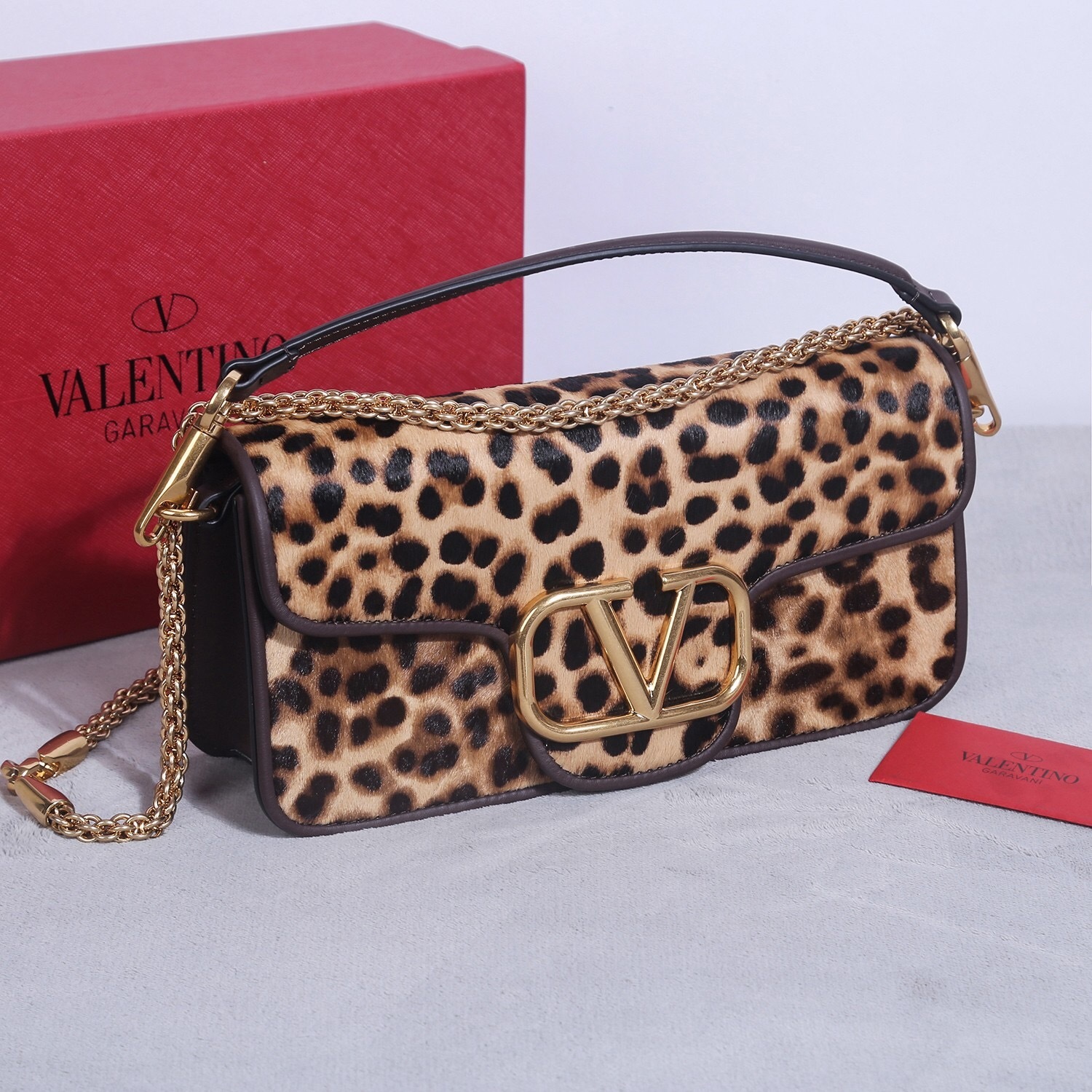 Valentino Garavani Locò shoulder bag made from leopard-print calf hair with gold-toned VLogo hardware and a detachable chain strap