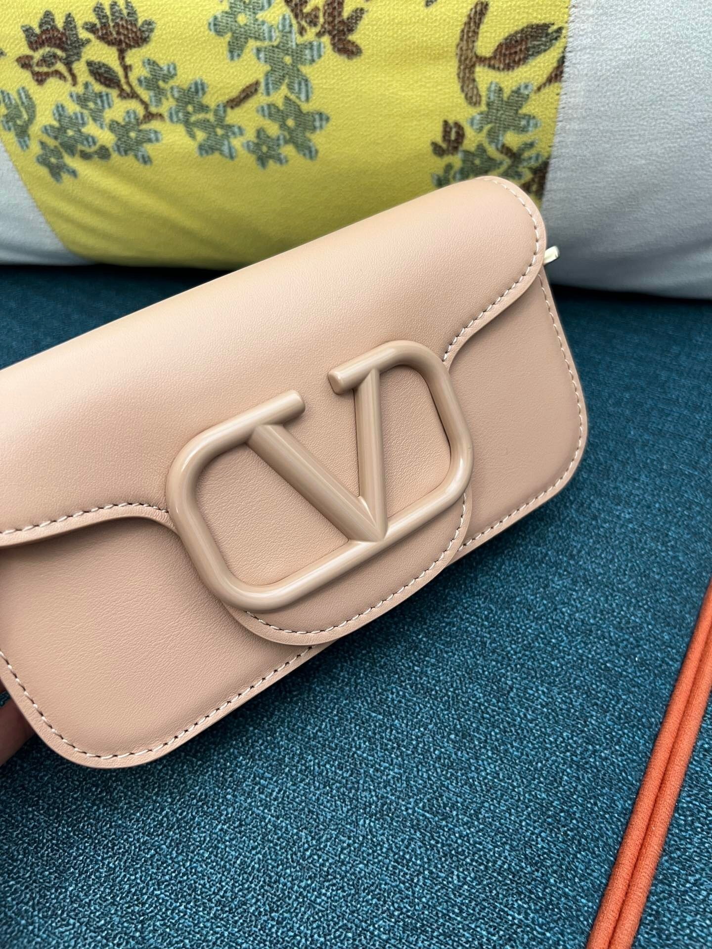Valentino Garavani Locò clutch bag in a nude or pink leather with a VLogo Signature plaque