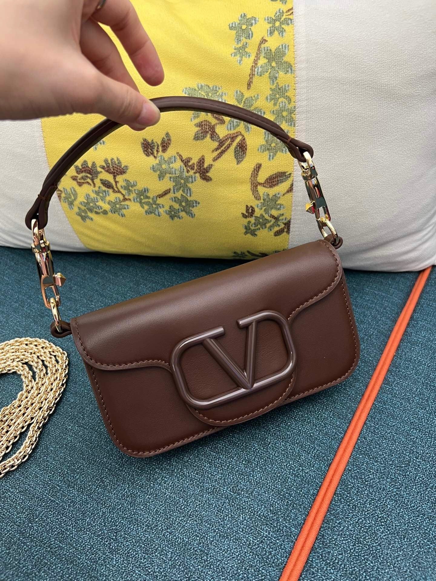 Valentino Garavani Locò small shoulder bag in brown calfskin leather with a VLogo Signature metallic element