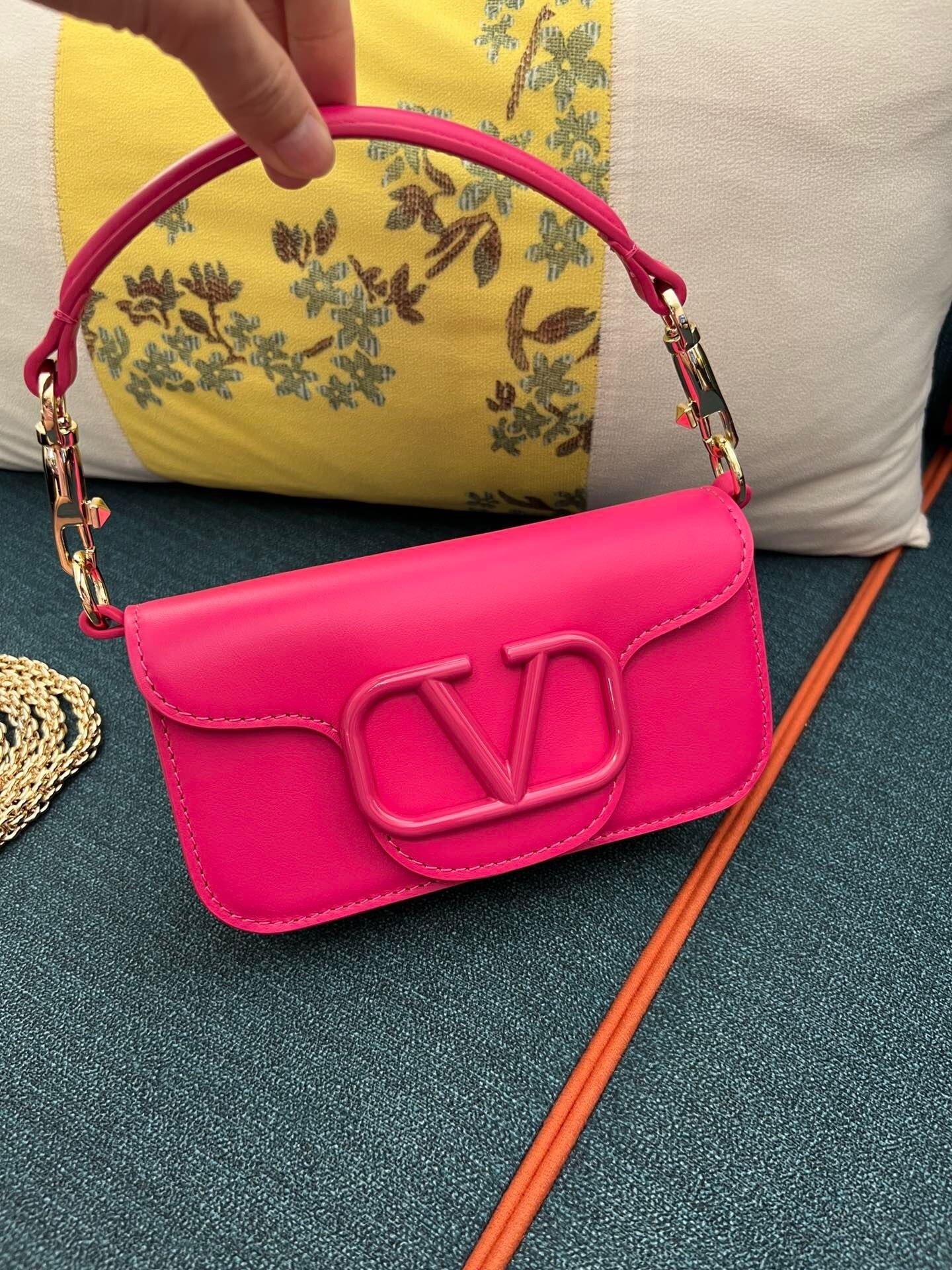 Valentino Garavani Locò small shoulder bag in calfskin leather, likely in a pink or fuchsia color