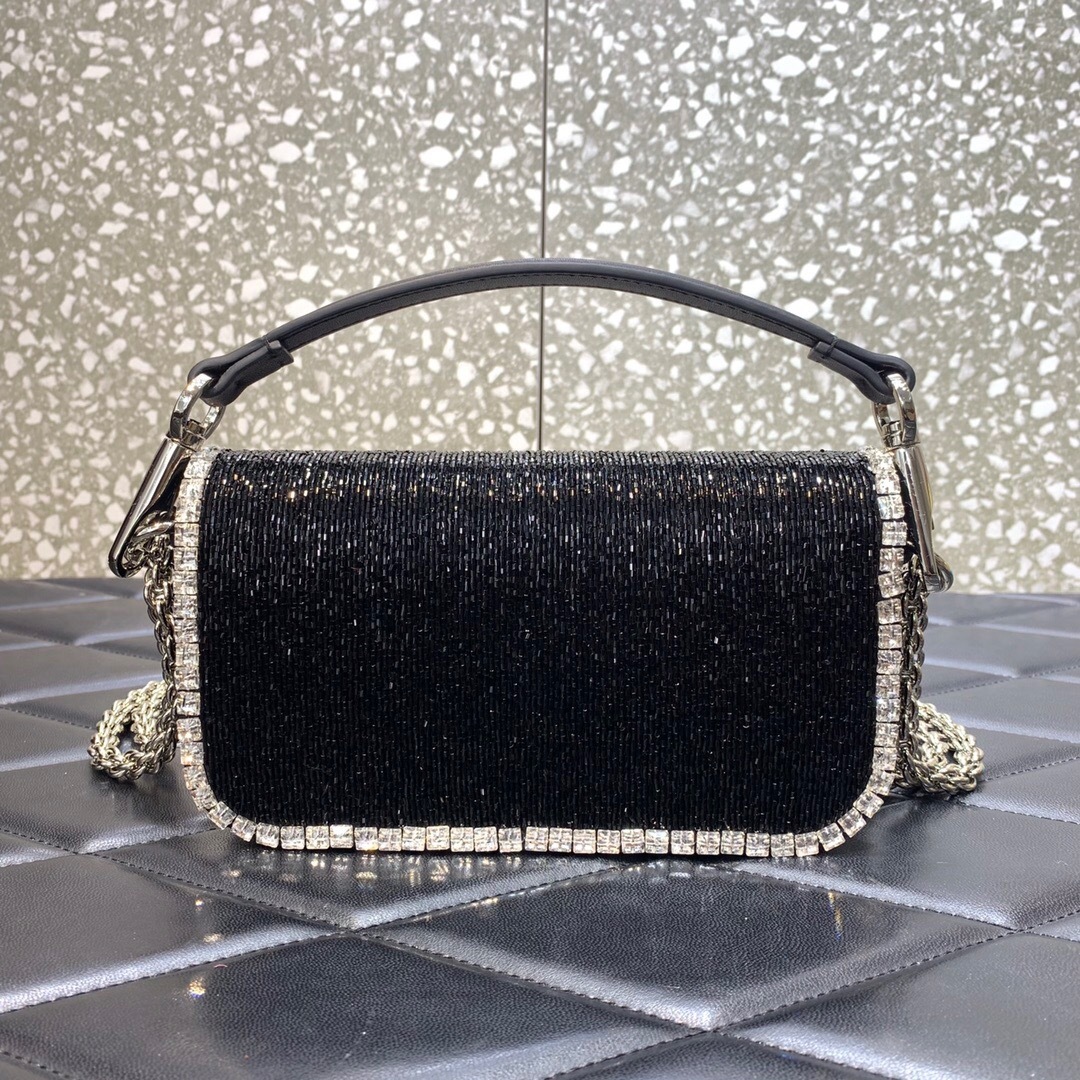 Valentino Garavani Locò small shoulder bag in black with crystal embellishments and a VLogo Signature element