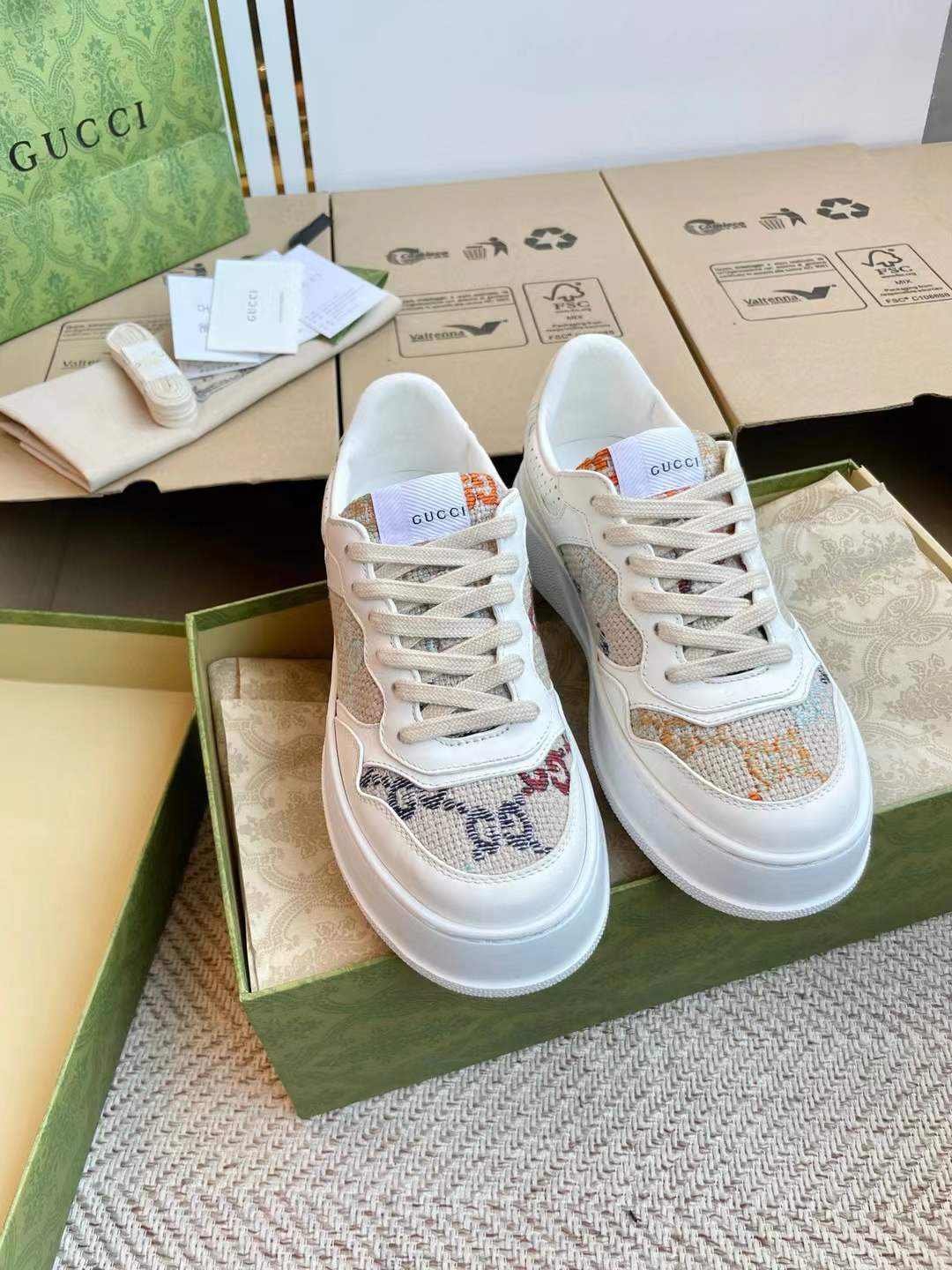 Gucci Women's GG sneaker in white and beige GG Supreme canvas with a brown leather trim.