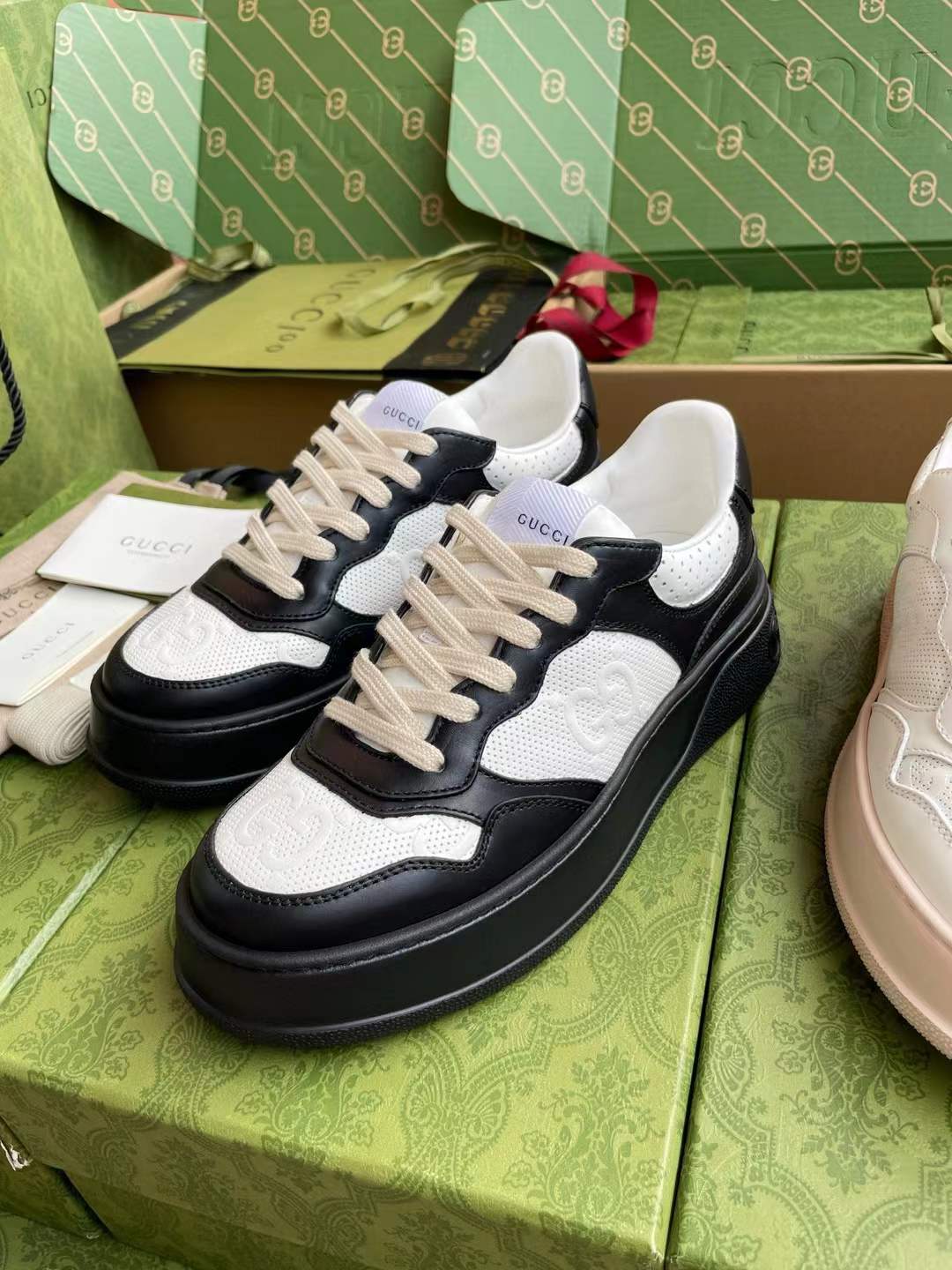 gucci black and white GG embossed low-top sneakers in leather and classic GG canvas.