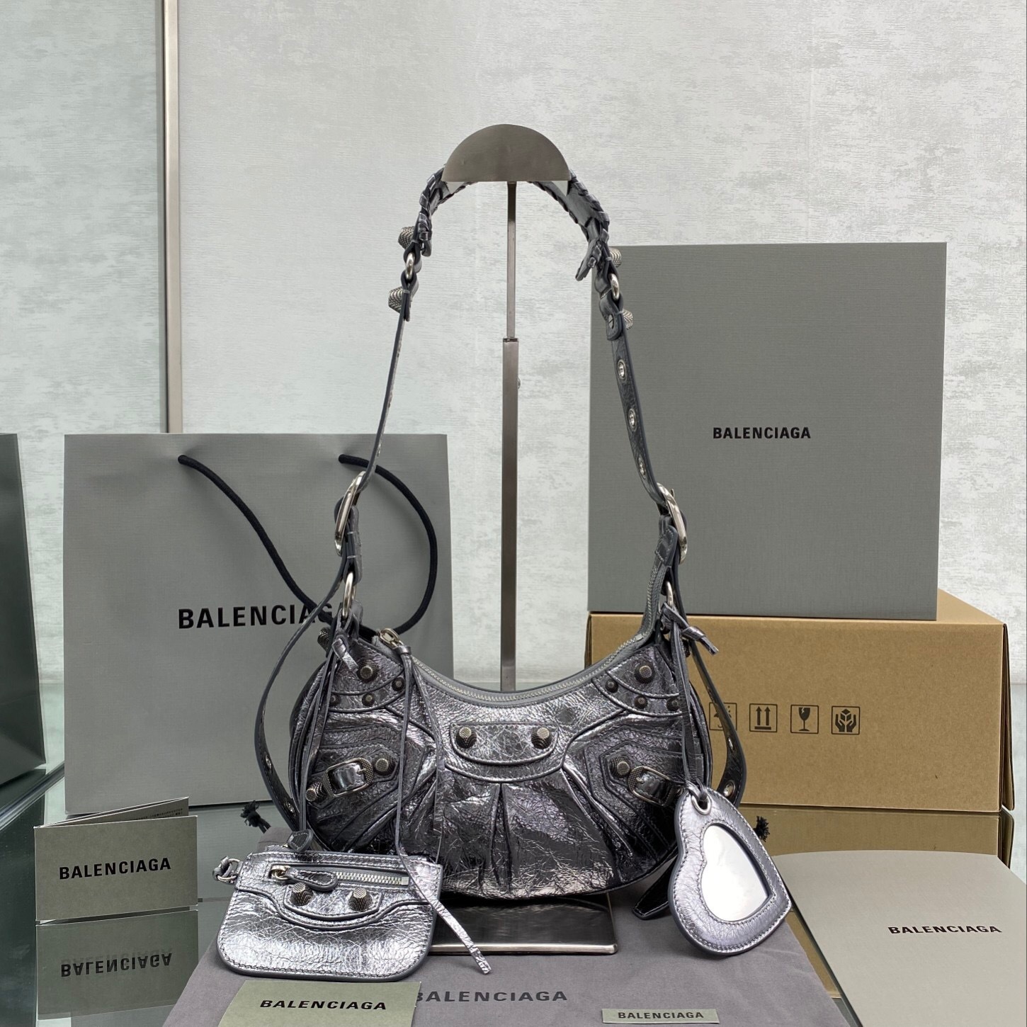Balenciaga Le Cagole XS shoulder bag in a metallic, crinkled-leather finish, likely silver or dark grey