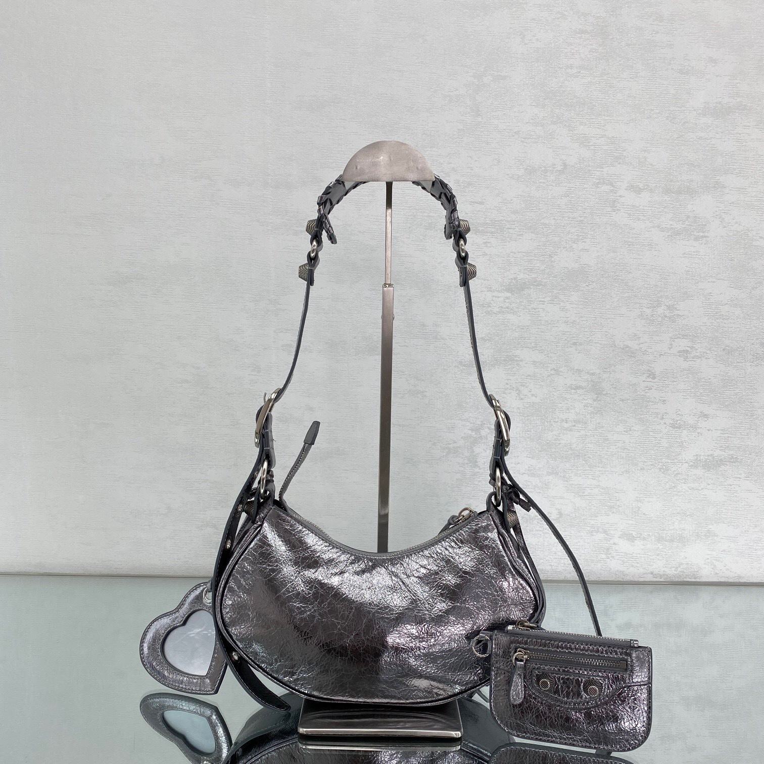Balenciaga Le Cagole XS shoulder bag in a metallic, crinkled-leather finish, likely silver or dark grey