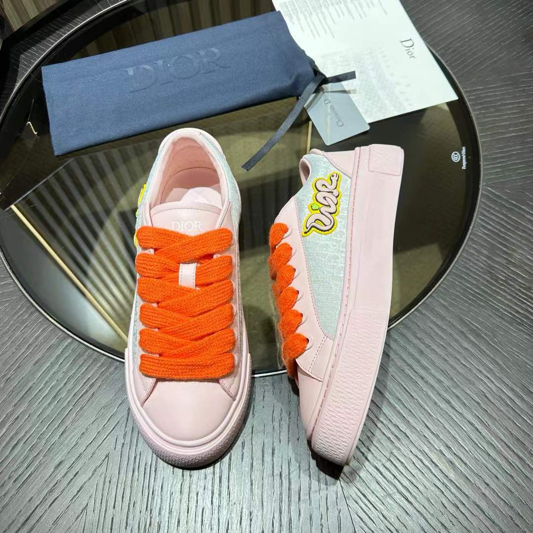 Dior x KAWS B33 low-top sneaker in a pink and grey colorway with vibrant orange laces