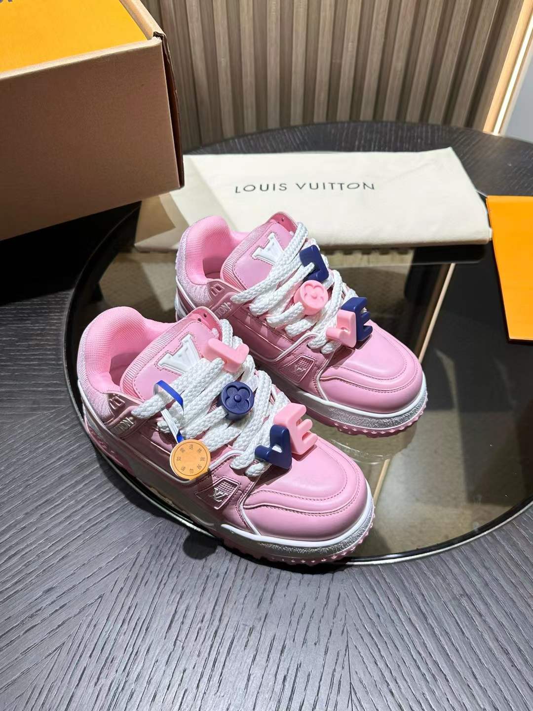 LV Trainer Maxi sneakers in pink, featuring oversized white laces with pink and blue charms.