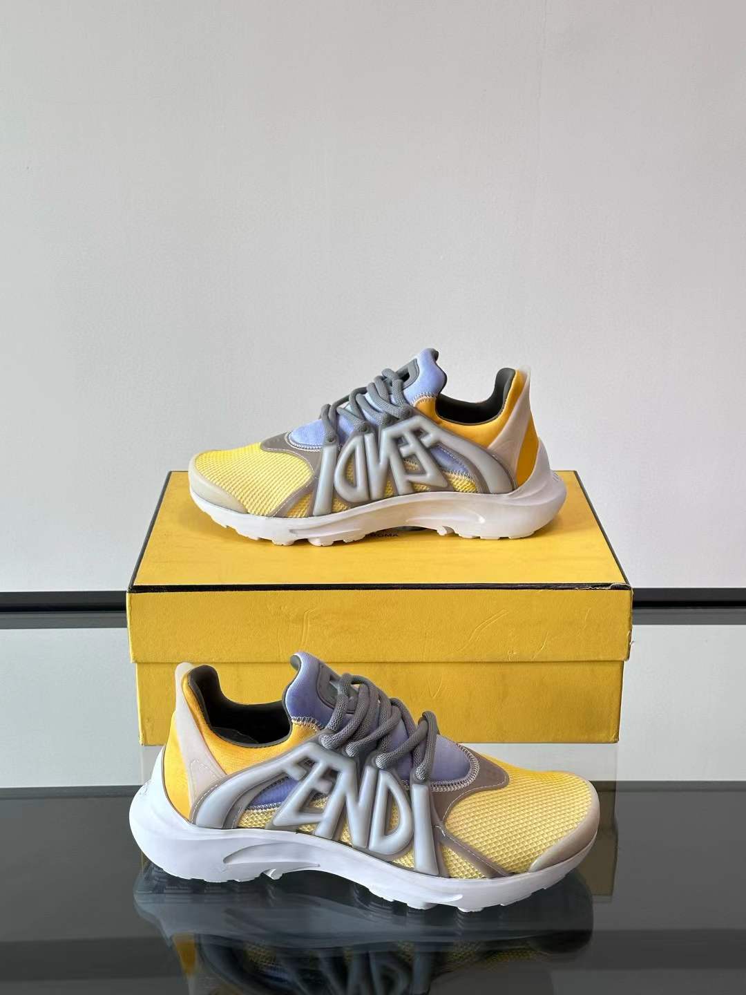 Fendi men's sneaker in a yellow and grey colorway with prominent Fendi lettering on the side
