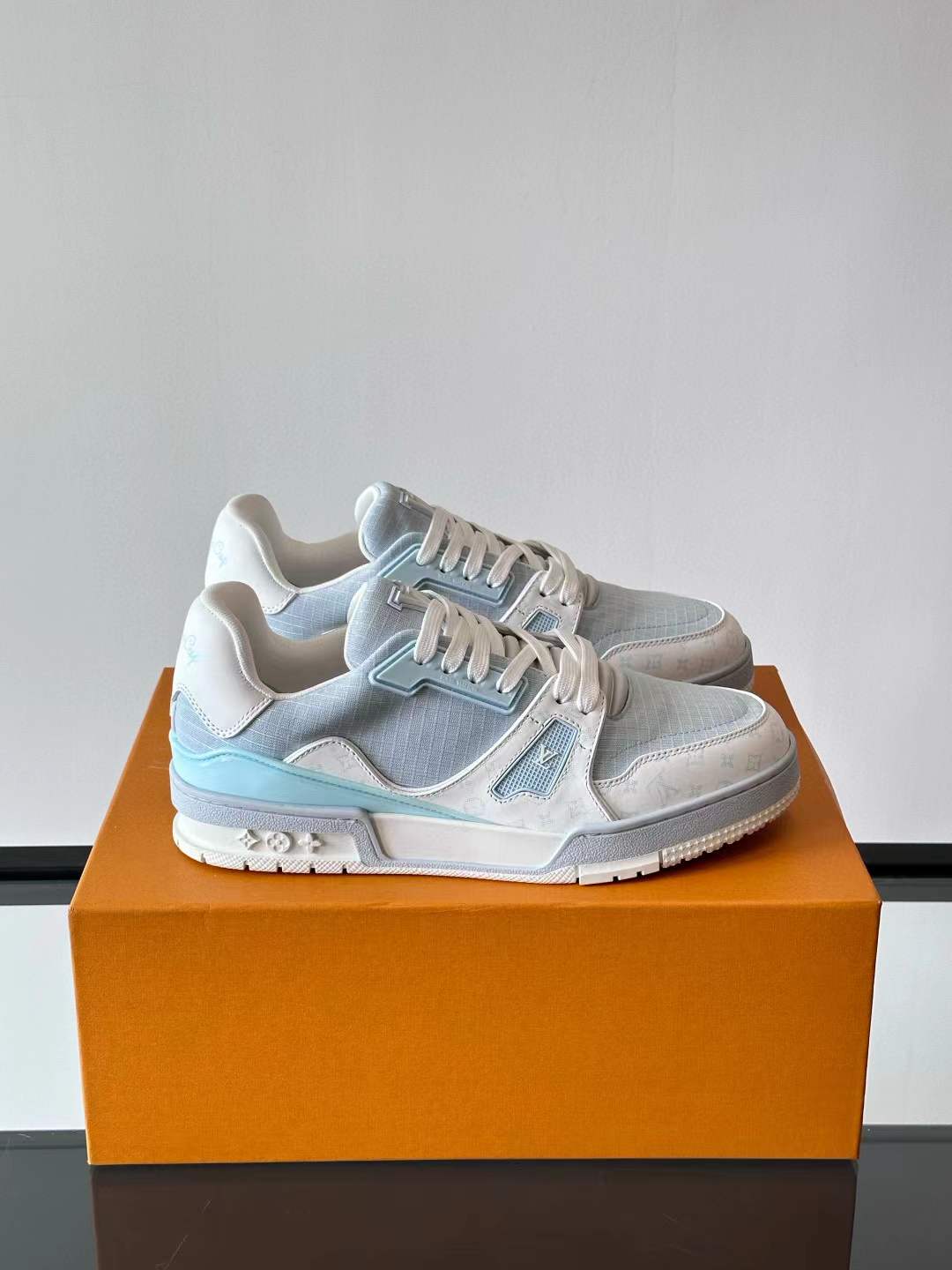 LV Trainer sneakers in a light blue denim and white color scheme