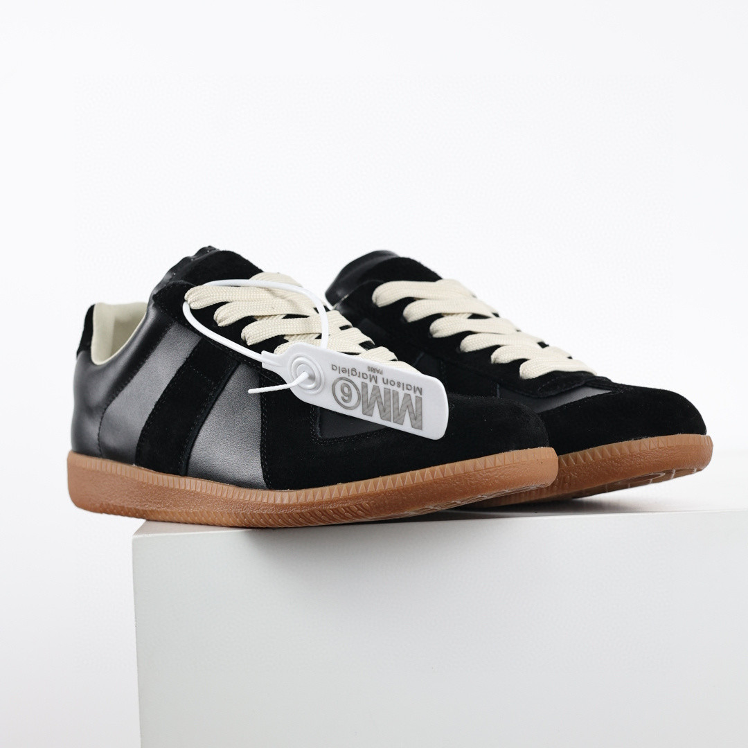 Maison Margiela low-top sneakers in black leather and suede with white laces and a flat rubber sole