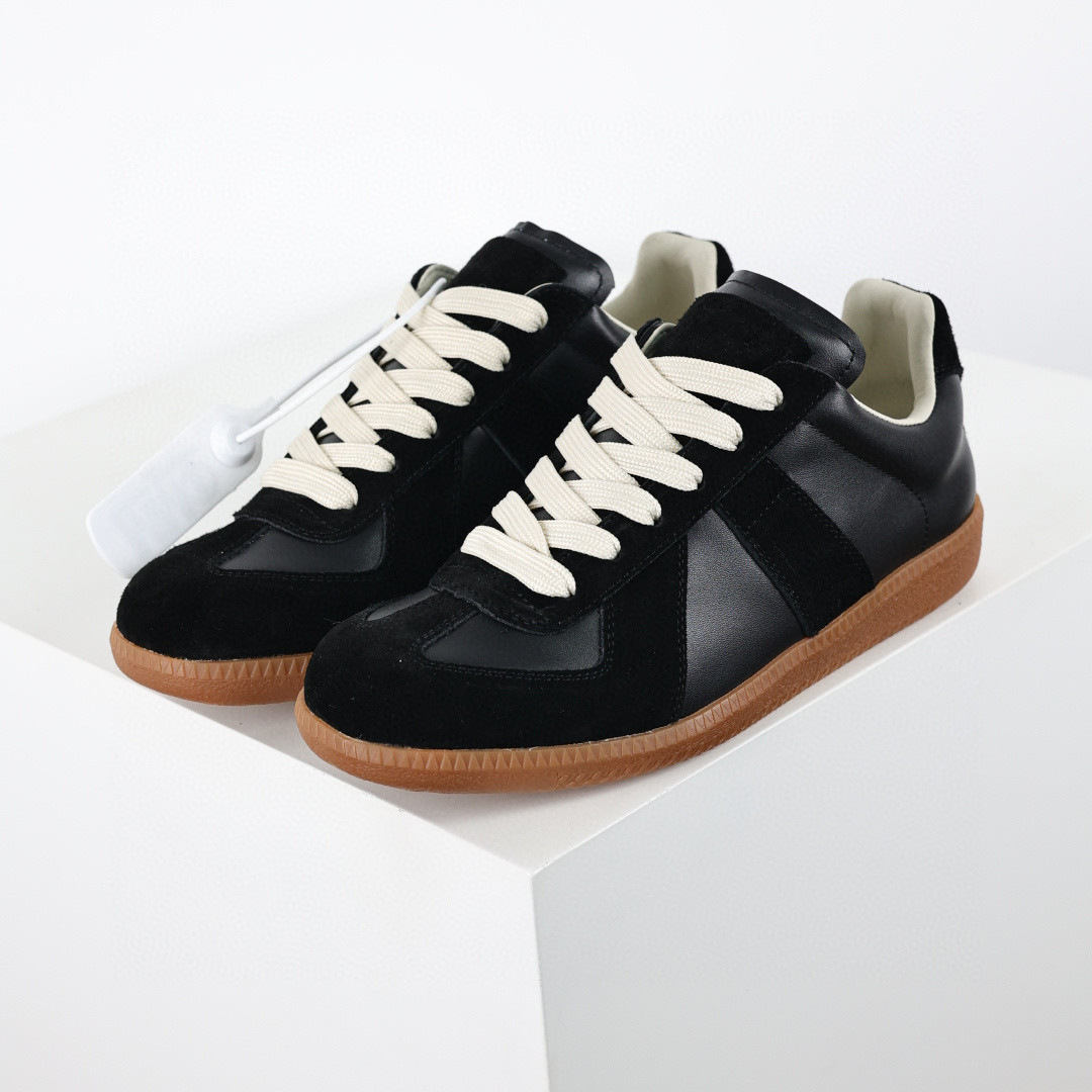 Maison Margiela low-top sneakers in black leather and suede with white laces and a flat rubber sole