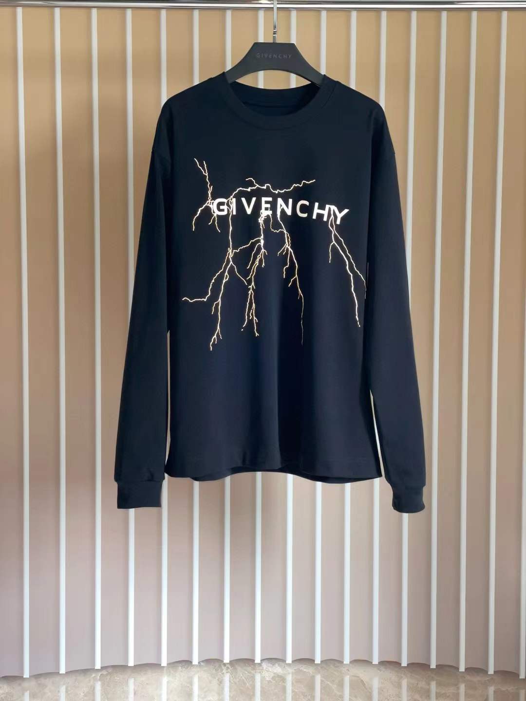 Givenchy Black sweatshirt with a white logo and gold lightning bolt graphic.