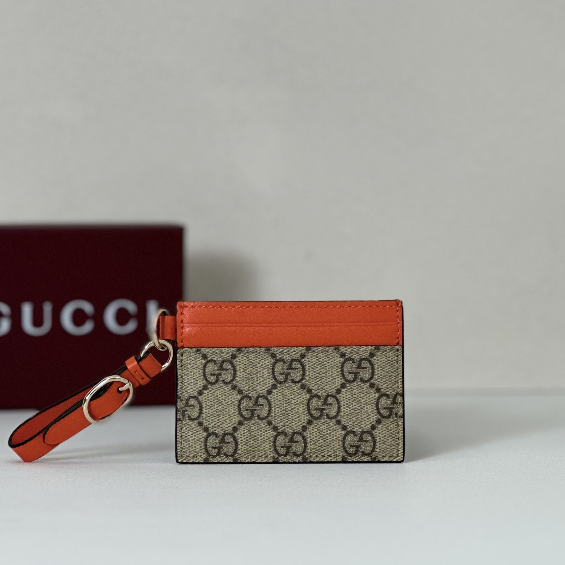 Gucci bi-color GG card case in beige and brown GG Supreme canvas with a vibrant orange leather trim