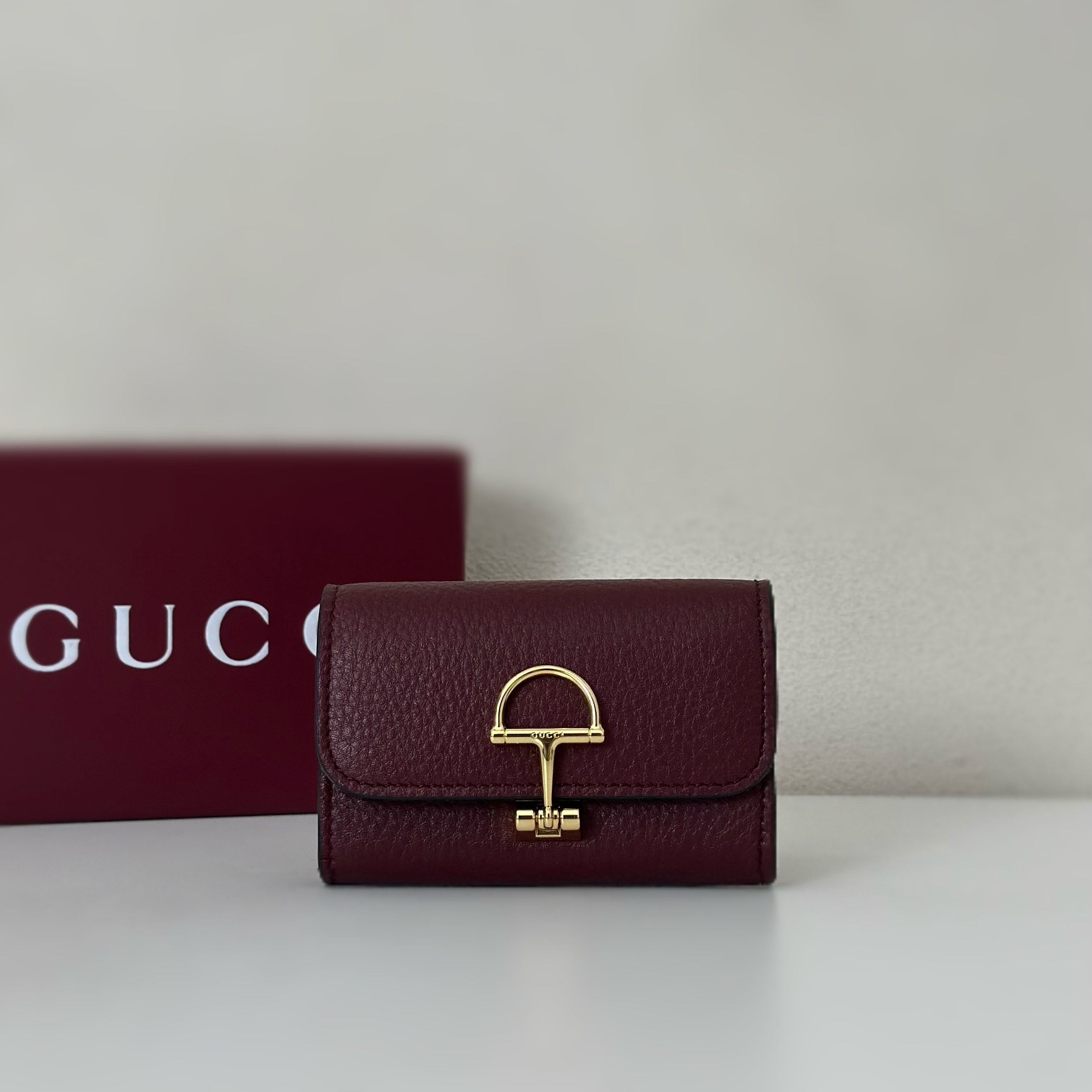 Gucci Softbit card case in the burgundy/Rosso Ancora red grainy calf leather with gold-tone horsebit hardware
