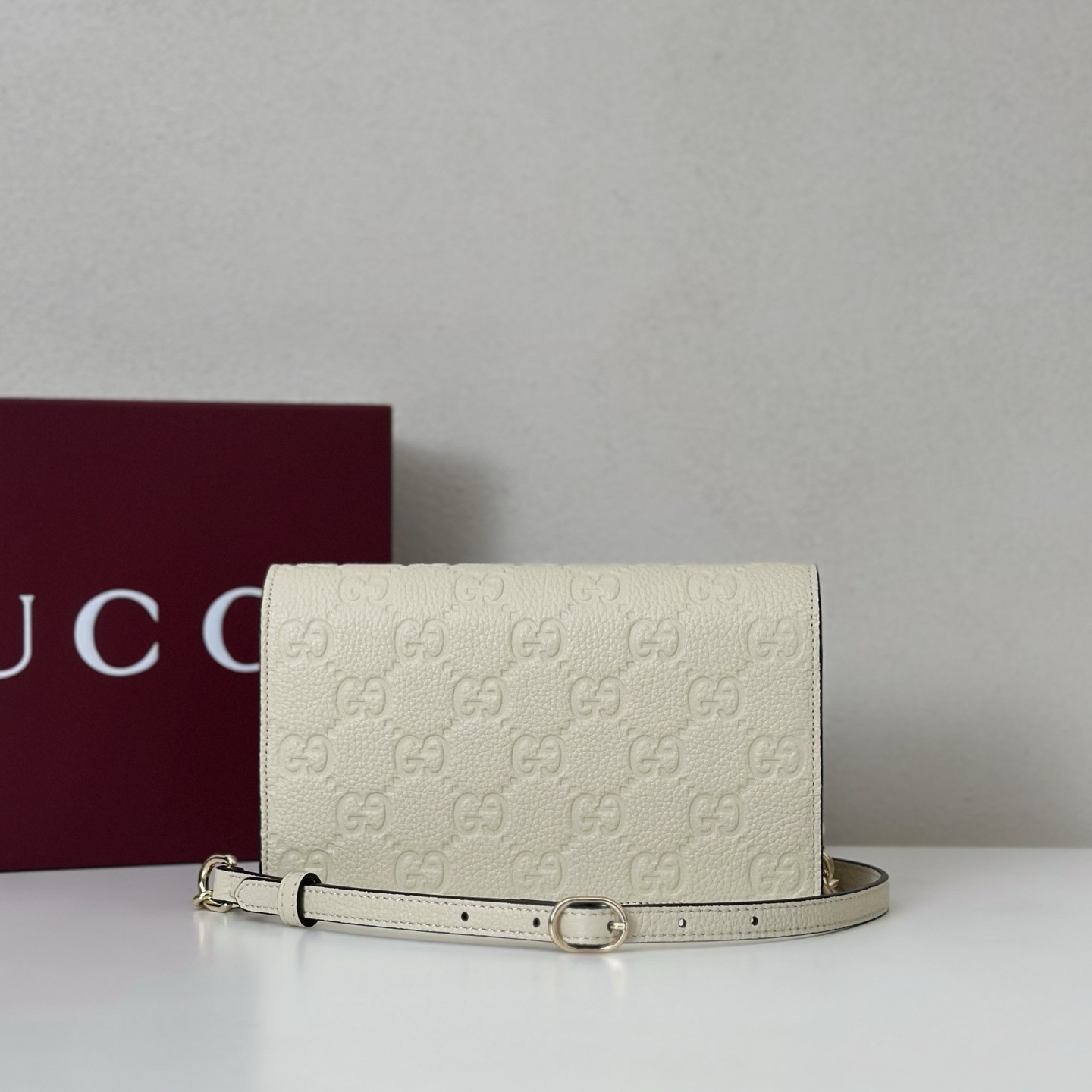 Gucci GG Embossed wallet on a chain in white or off-white leather