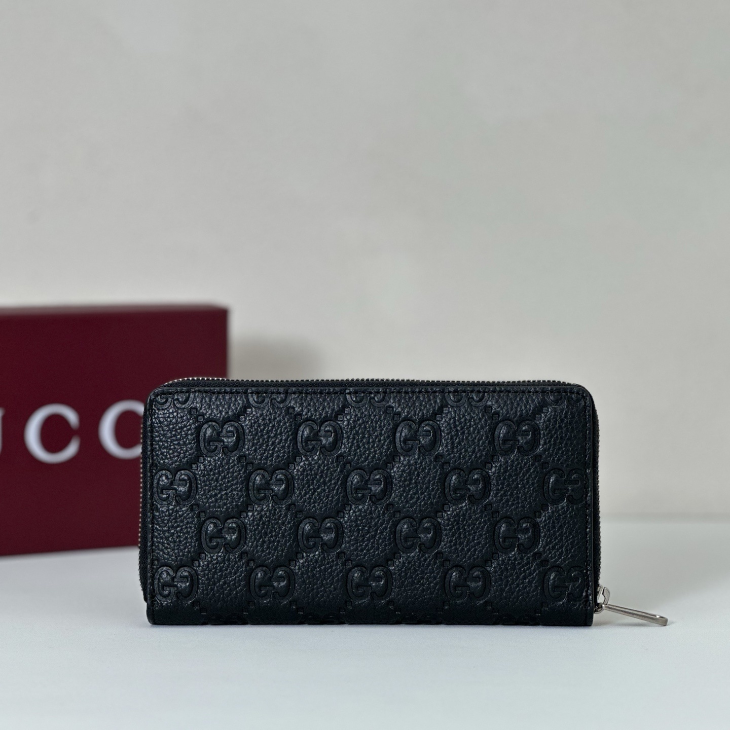 Gucci Imprint zip around long wallet in black embossed GG grainy leather
