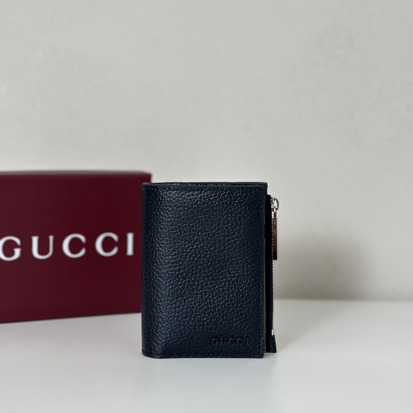 Gucci GG Supreme Small Coin Wallet in a navy blue color and textured leather material