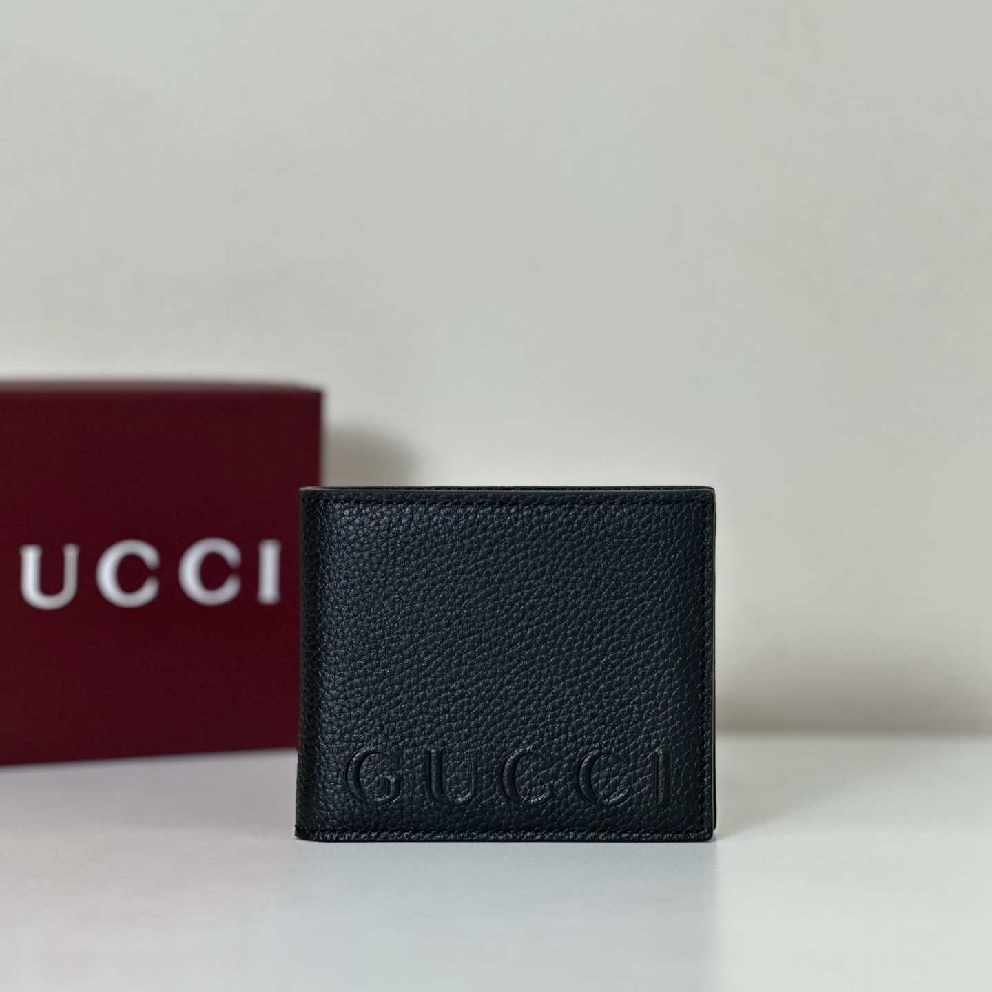 Gucci black leather bi-fold wallet with an embossed logo