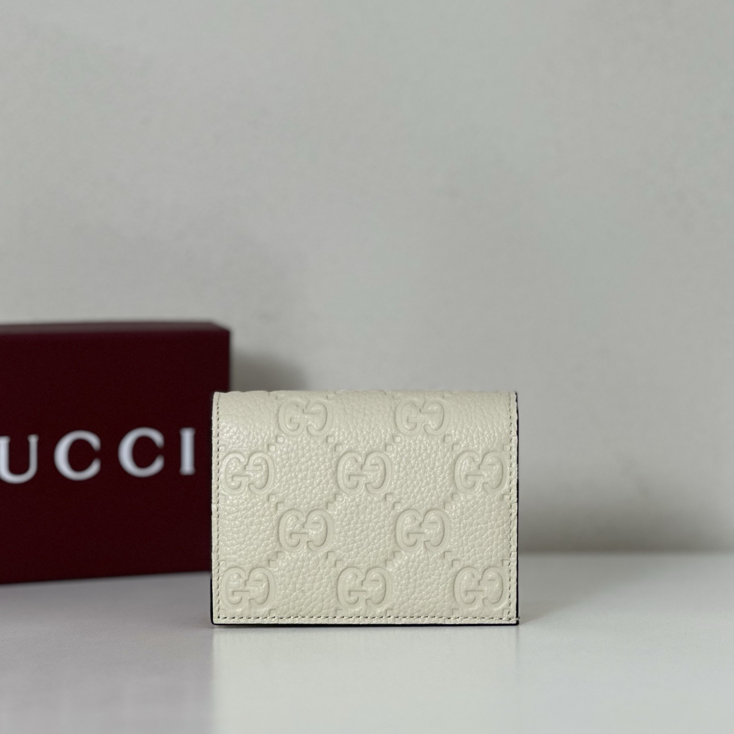 Gucci wallet the iconic GG emblem pattern.