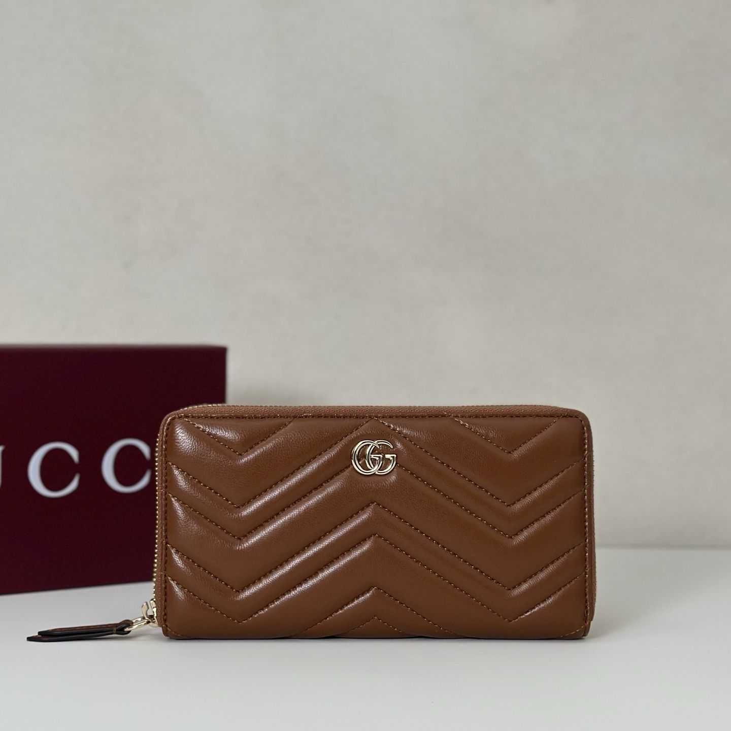 Gucci GG Marmont zip around wallet in brown matelassé chevron leather with light gold-toned hardware