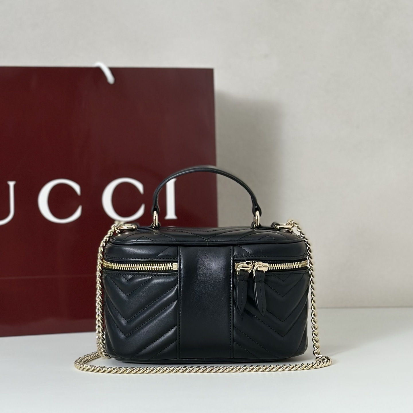 Gucci GG Marmont mini vanity bag in Black matelassé chevron leather with light gold-toned hardware.
