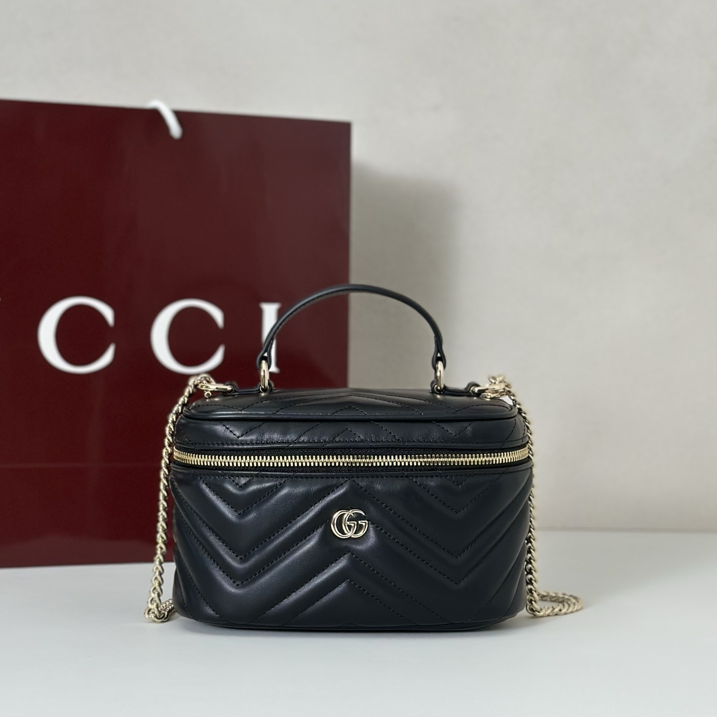 Gucci GG Marmont mini vanity bag in Black matelassé chevron leather with light gold-toned hardware.