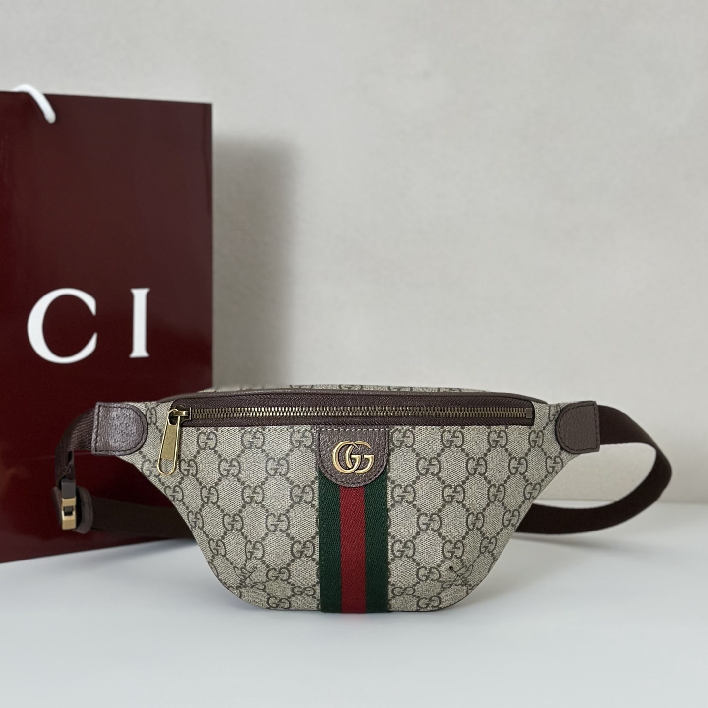 Gucci Ophidia small belt bag in beige and dark brown GG monogram coated fabric with an oval enamel Double G logo detail and the signature Web stripe