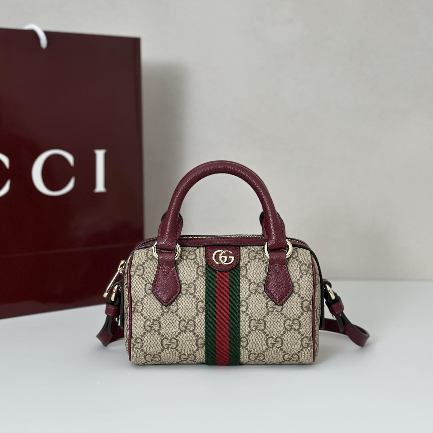 Gucci Ophidia Mini top handle bag in the GG Supreme canvas with a red leather trim