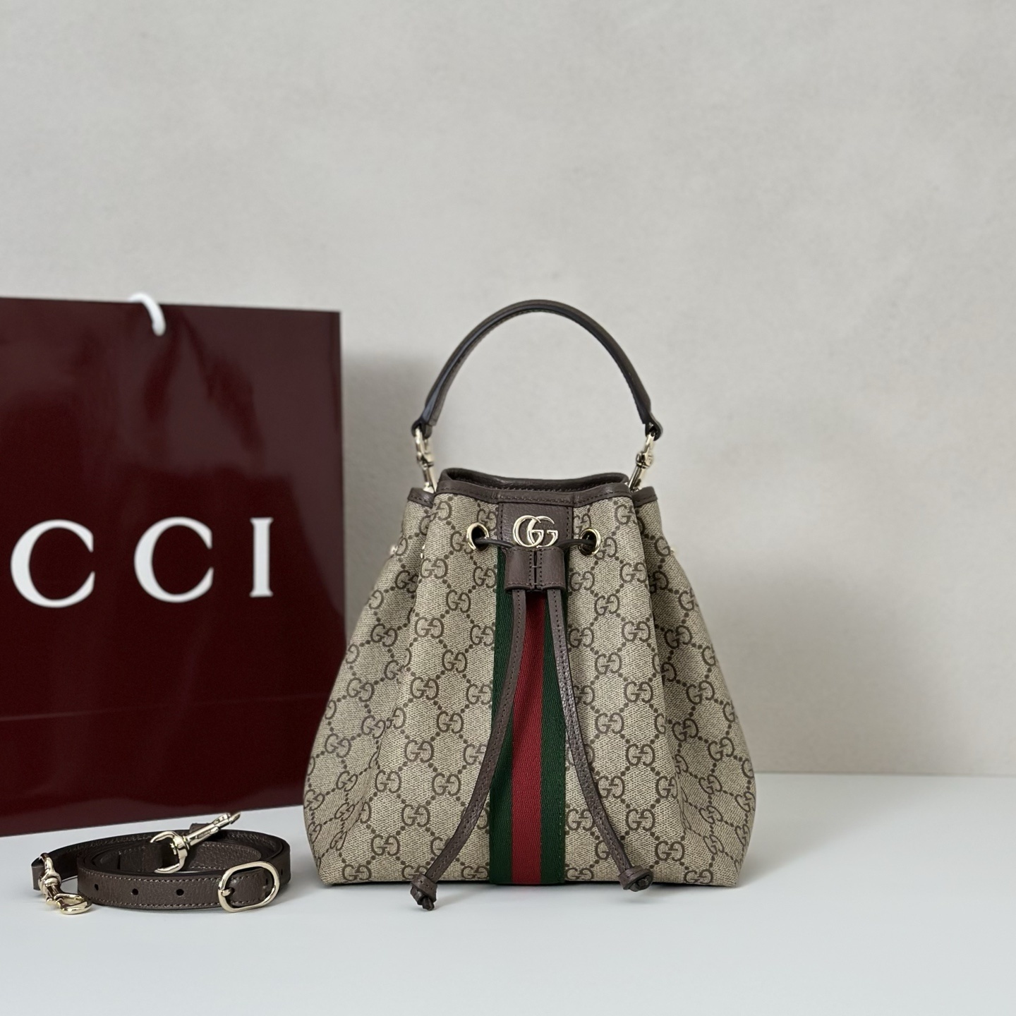 Gucci Ophidia small bucket bag in the signature beige and brown GG fabric with the green and red Web stripe