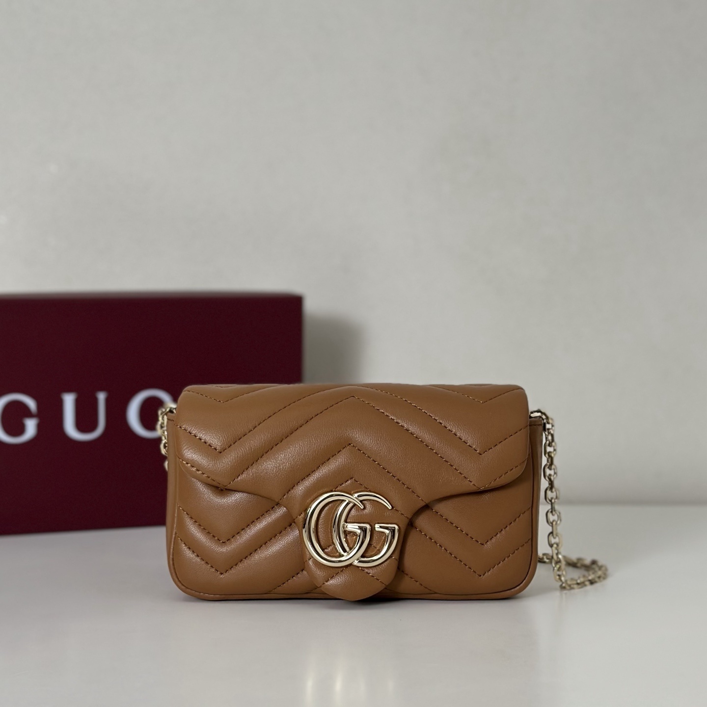 Gucci GG Marmont mini shoulder bag in brown matelassé leather with antique gold-toned hardware
