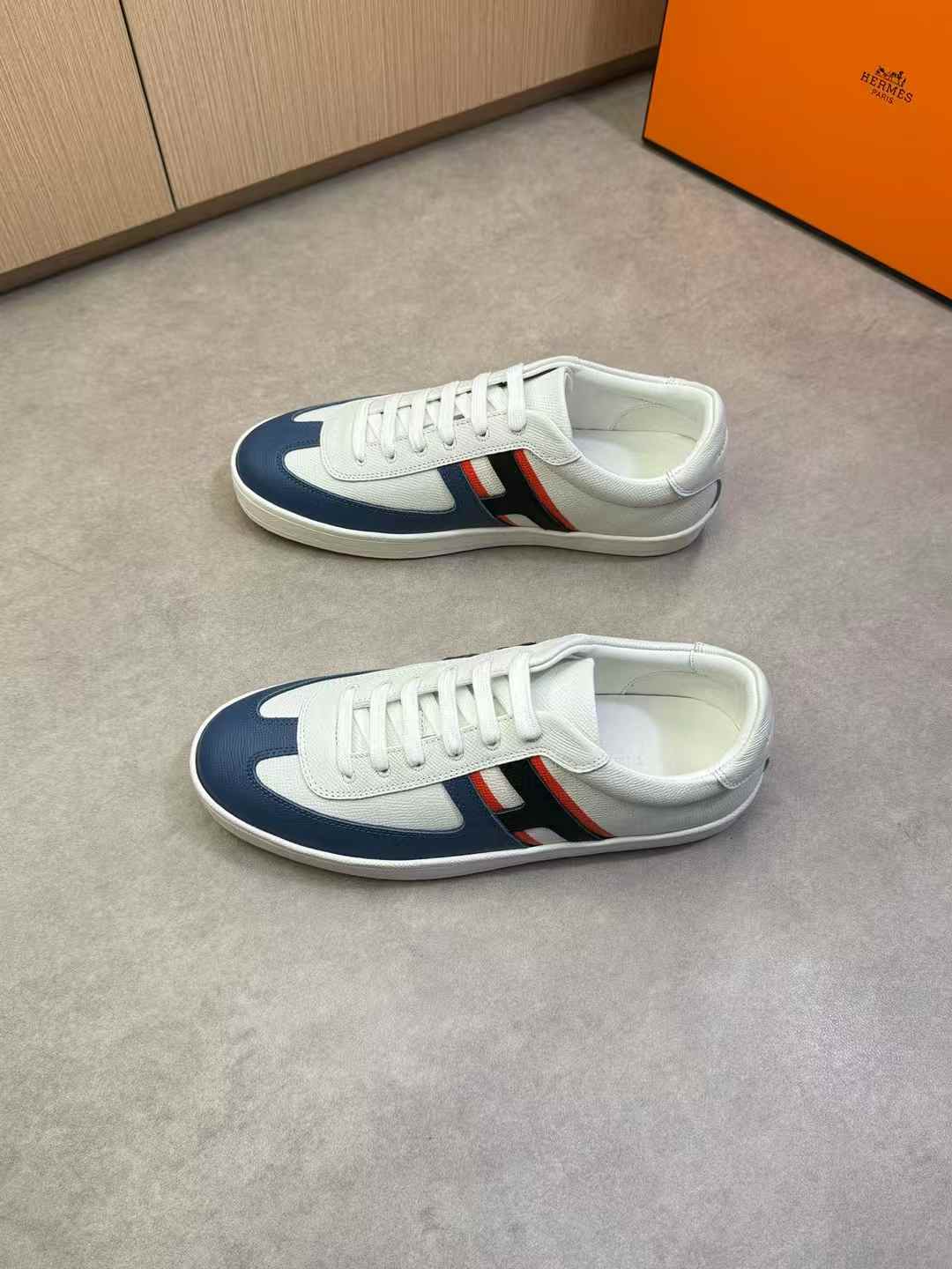 Hermes Boomerang sneakers in white Epsom calfskin with a blue toe and the iconic orange sole