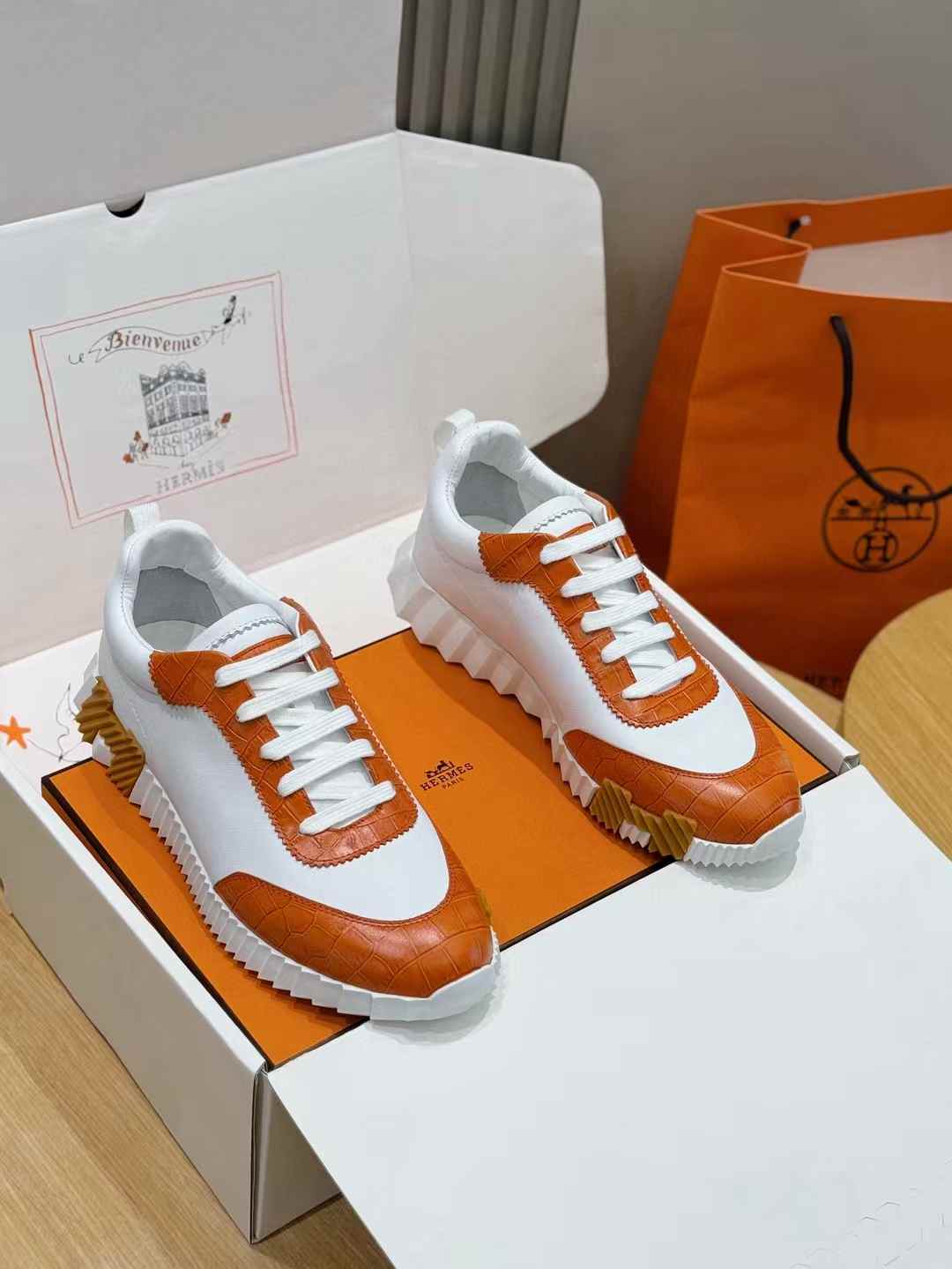 Hermès Bouncing sneakers in white leather with an orange crocodile or alligator-effect trim
