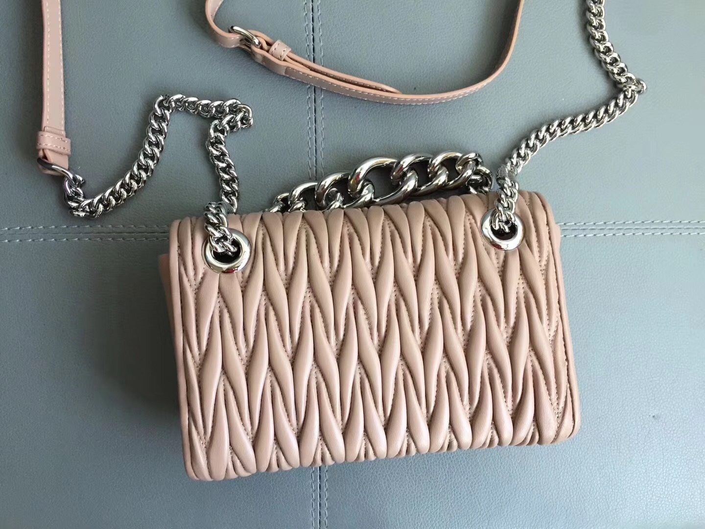 Miu Miu Club matelasse nappa leather shoulder bag in a pink/cameo hue.