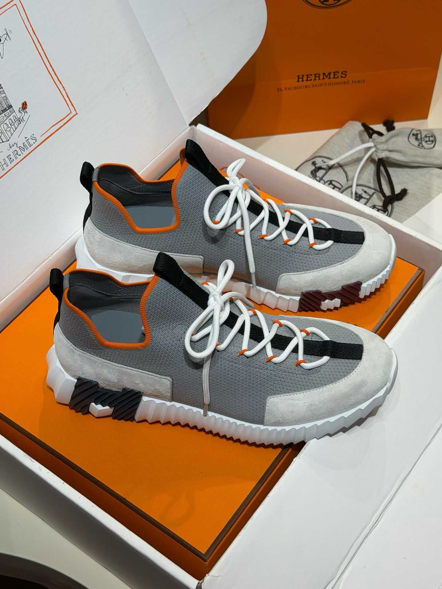 Hermès "Bouncing" sneakers in a grey and orange colorway with a white rubber sole