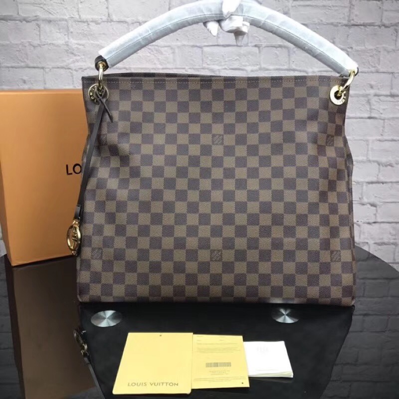 LV Artsy MM bag in the Damier Ebene canvas with a looping vachetta handle