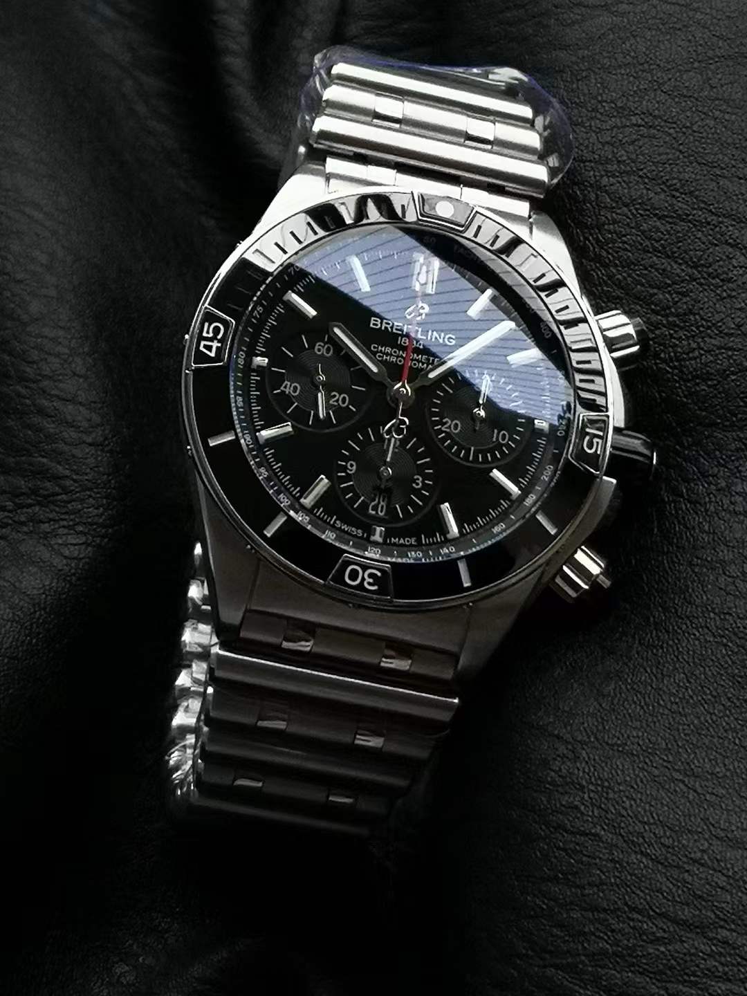 Breitling Super Chronomat B01 44 watch with a black dial and a stainless steel case and bracelet