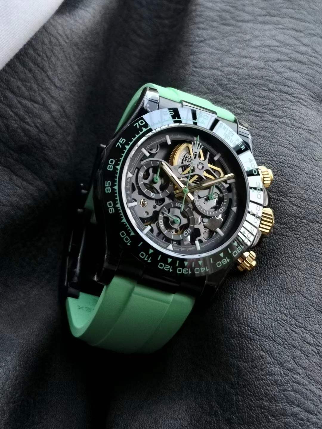 Rolex Daytona skeletonized watch, potentially a "Skeleton Concept" edition or similar custom build, featuring a black case, gold-tone pushers and crown, and a green rubber strap