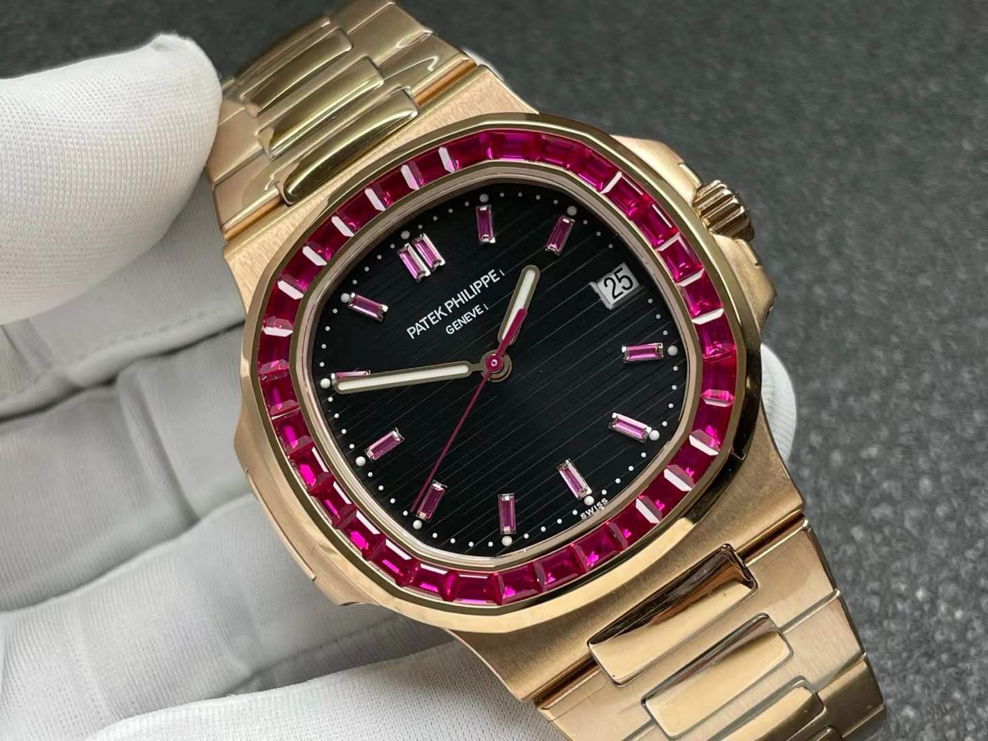 Patek Philippe Nautilus 5723/112R-001 in 18k rose gold with a black sunburst dial, a bezel set with 32 baguette-cut rubies, and ruby hour markers