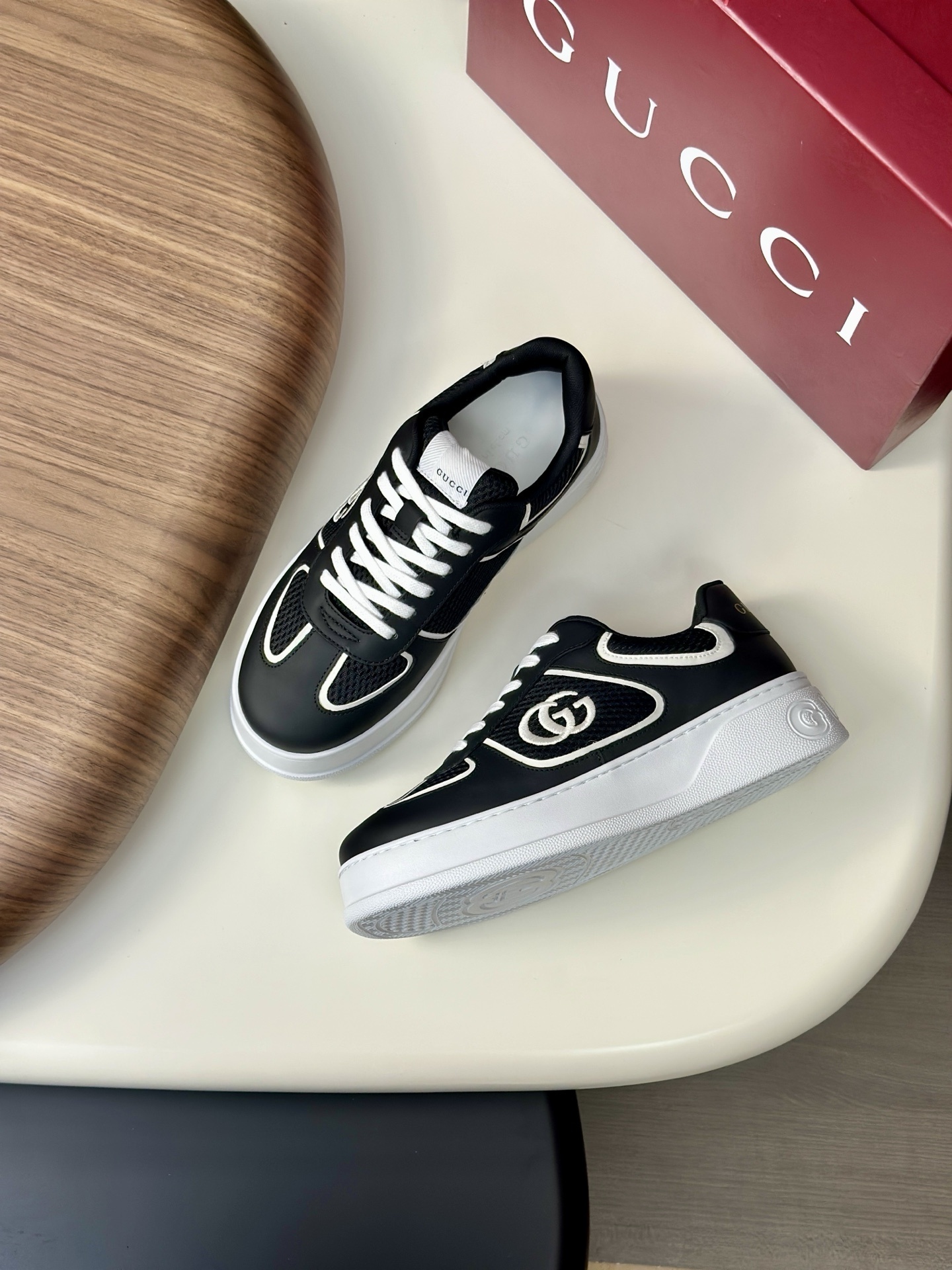 Gucci low-top sneakers in black and white leather with the signature Interlocking G logo.