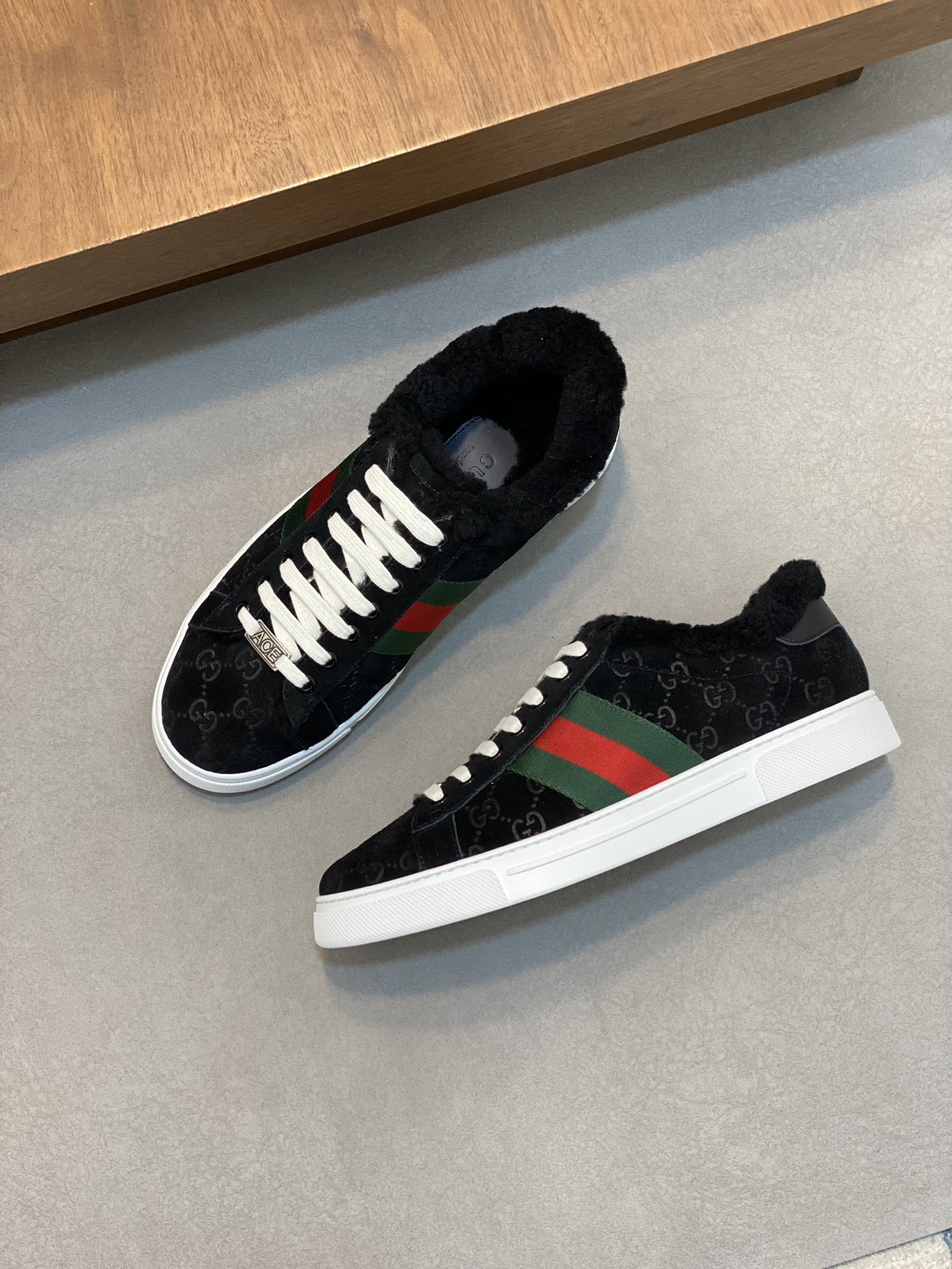 Gucci Ace sneakers with the signature green and red Web stripe, an 'ACE' label plaque on the laces, and a fur lining.